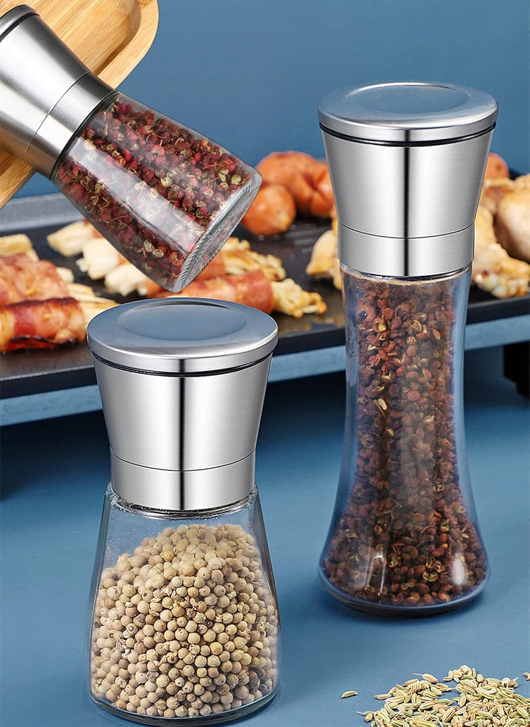 Zwei Gewürzstreuer aus Glas und Metall, gefüllt mit Pfefferkörnern und weißem Pfeffer.