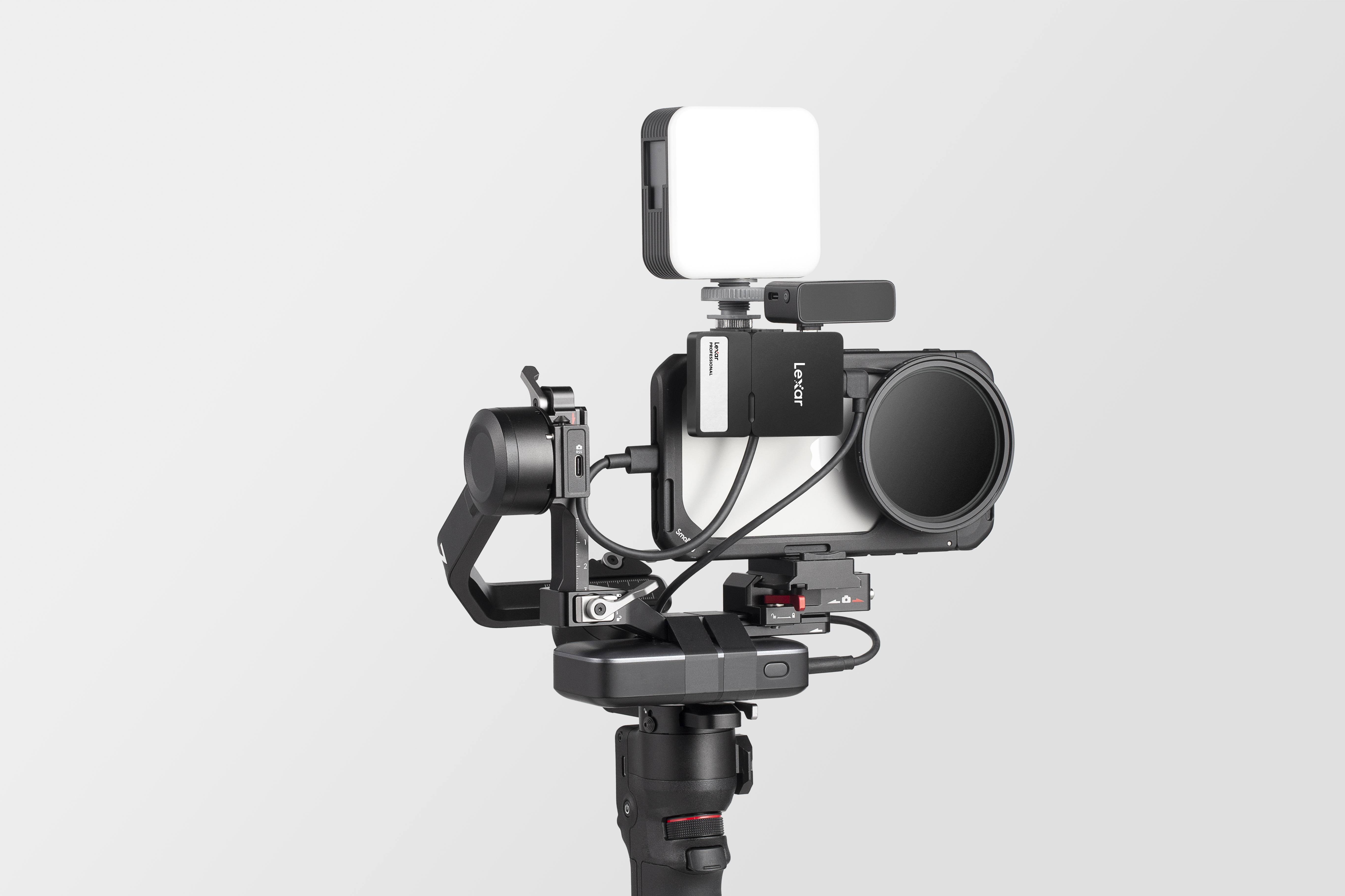 Un rig de cardán con cámara, luz y filtro de lente sobre fondo gris.