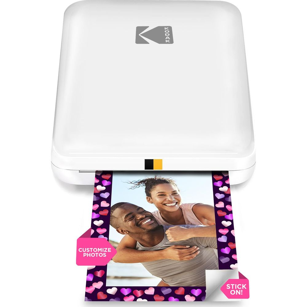 Una impresora fotográfica Kodak blanca imprime una foto de pareja con borde de corazón.
