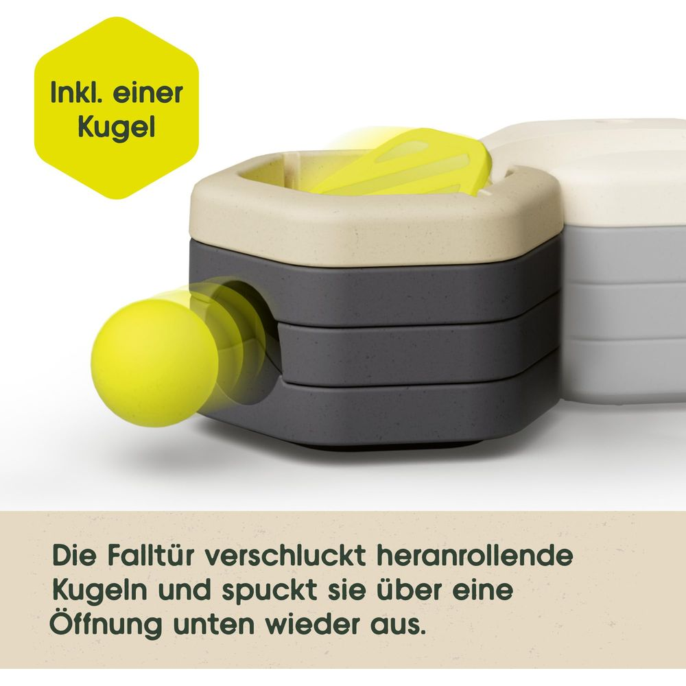 Gelbe Kugel rollt in graues Spielzeug. Enthält eine Kugel.