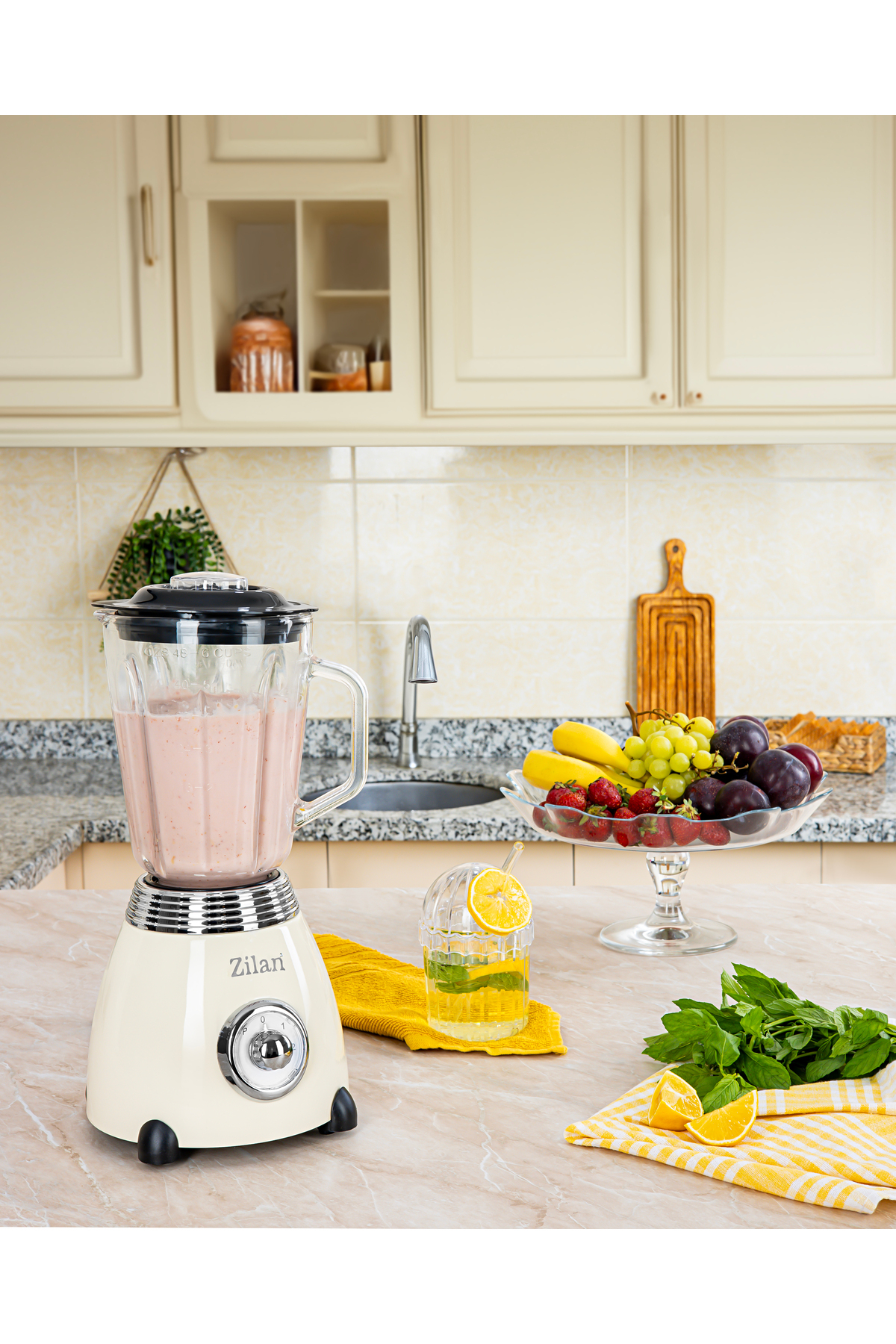 Krem rengi blender, smoothie bardağı, meyve kasesi ve içecekle.