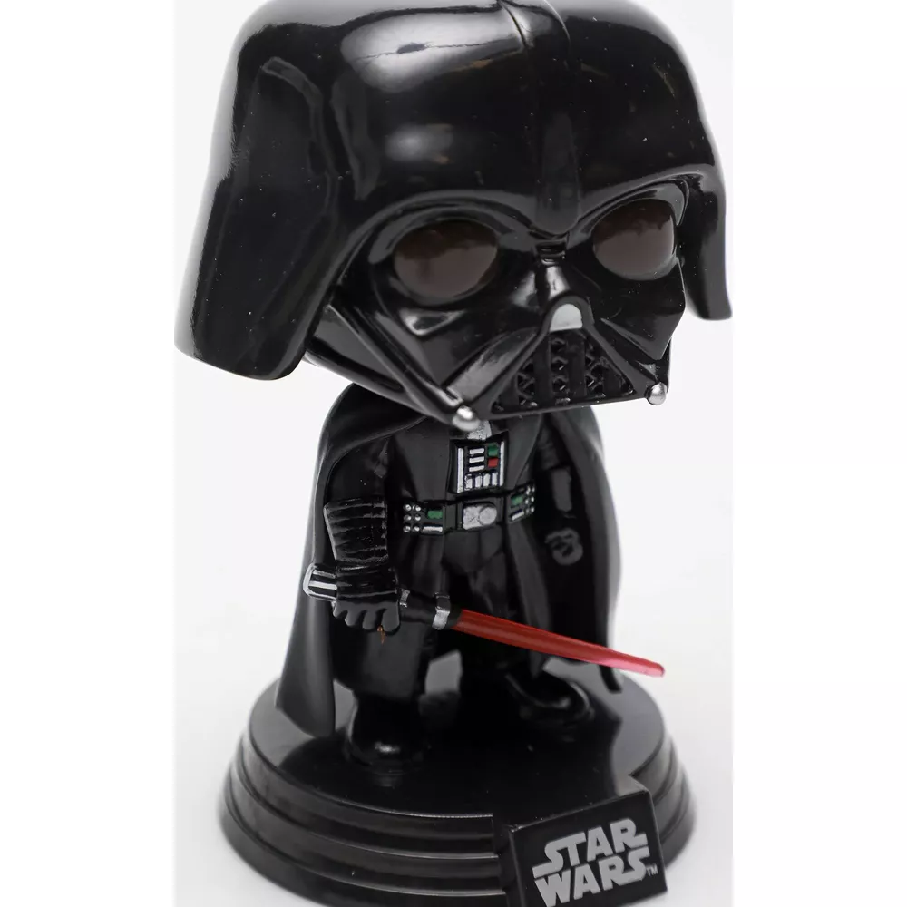 Darth Vader Figur mit rotem Lichtschwert und Star Wars Logo.
