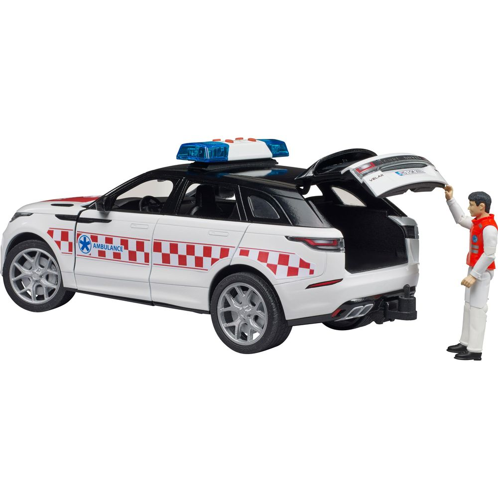 Ein weißer Spielzeug-Rettungswagen mit geöffneter Heckklappe und einem Mann in Uniform daneben.