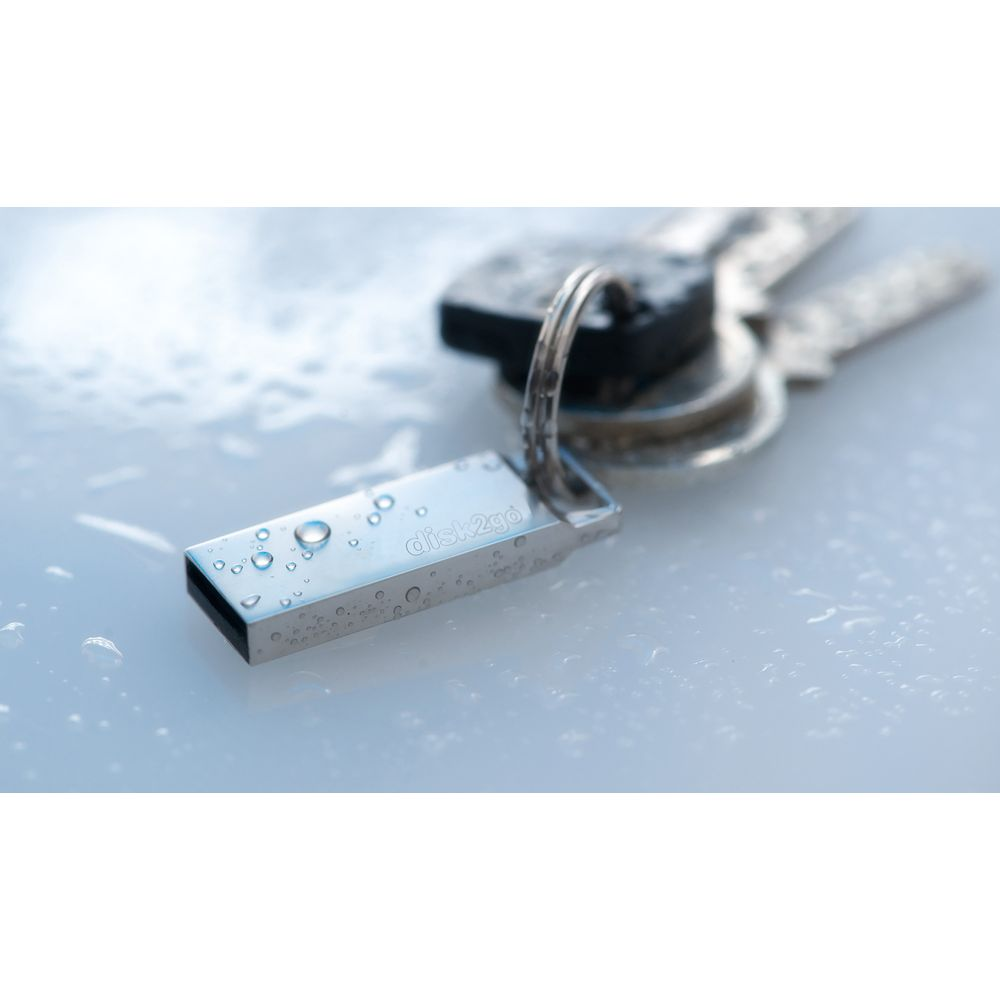 Une clé USB argentée avec des gouttelettes d'eau et des clés sur une surface humide.