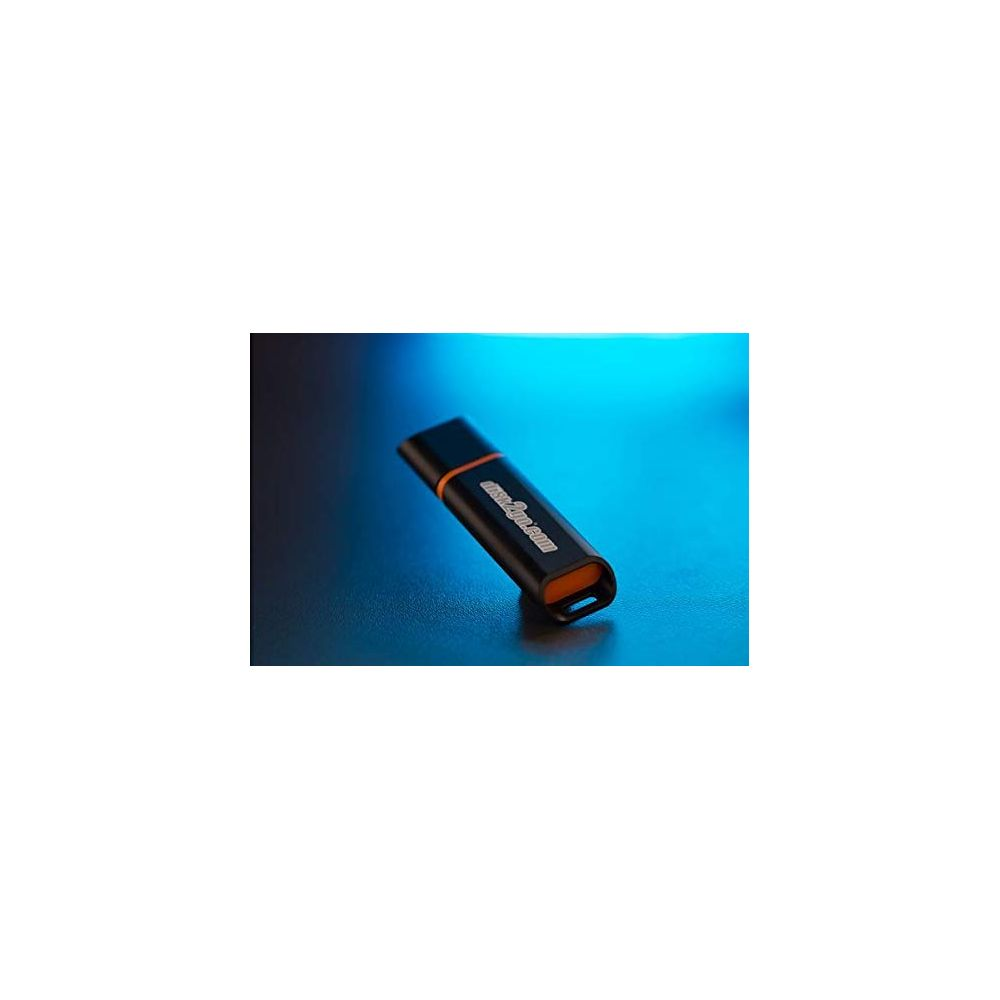 Une clé USB noire avec un accent orange repose sur une surface sombre.