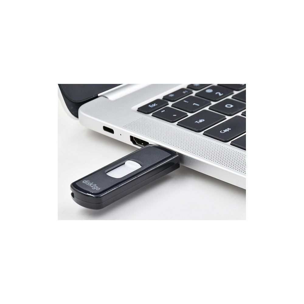 Une clé USB noire avec curseur blanc branchée sur un ordinateur portable.