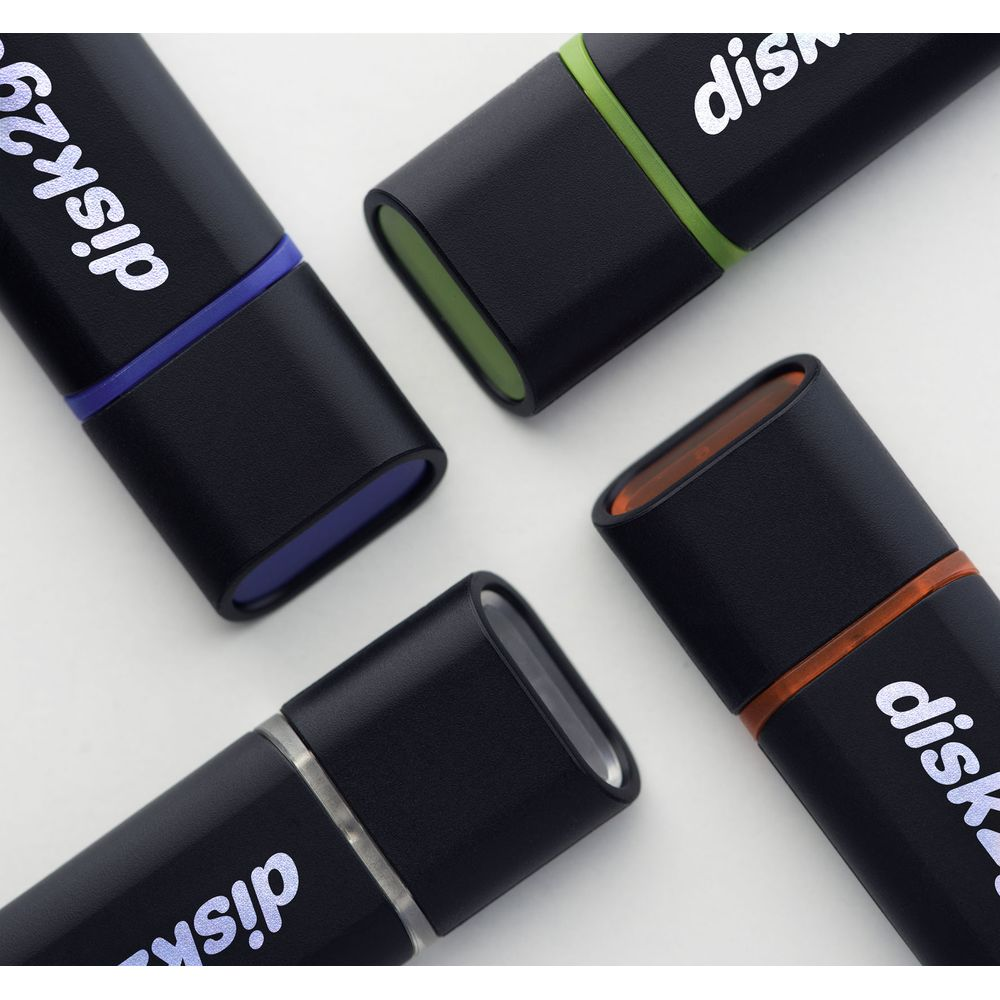 Vier schwarze USB-Sticks mit farbigen Akzenten: blau, grün, orange und silber.
