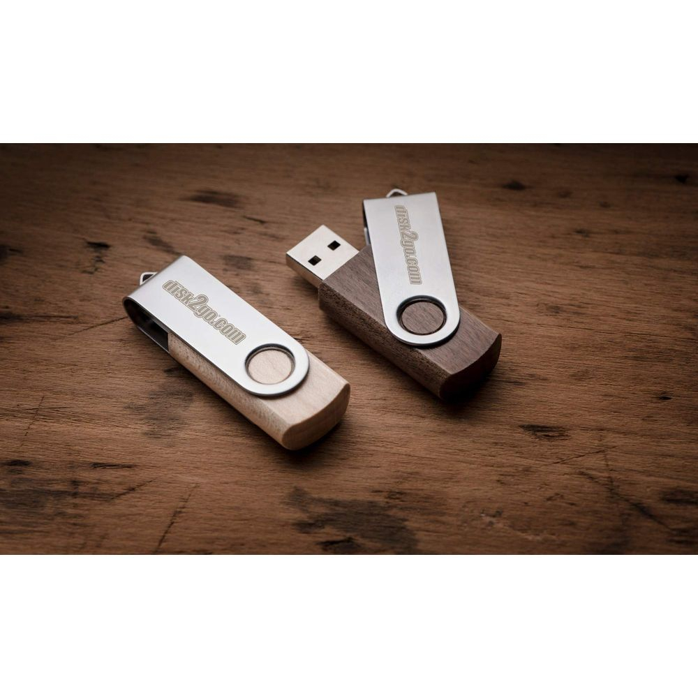 Deux clés USB en bois avec capuchons en métal sur une surface en bois.