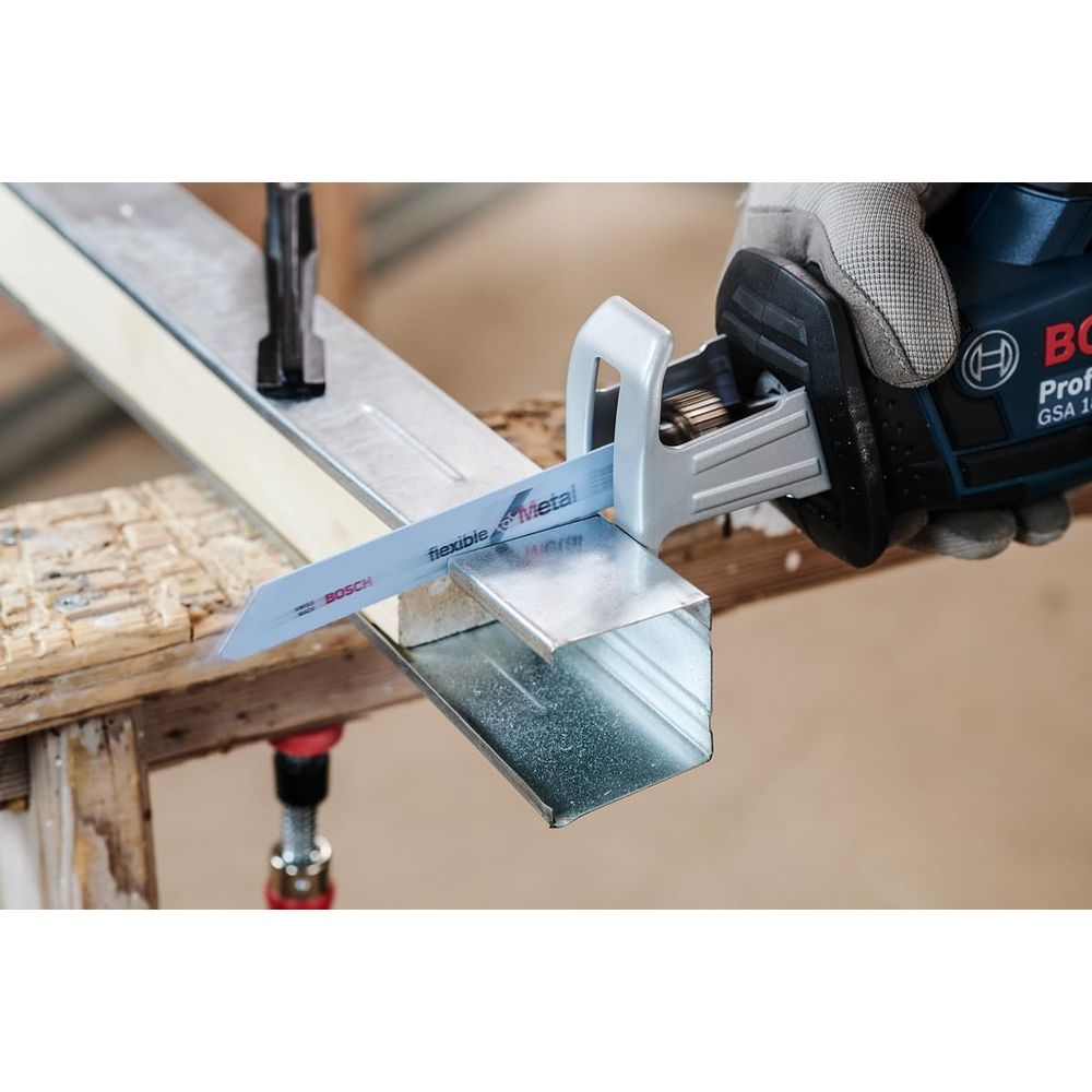 Ein Bosch Säbelsäge schneidet ein Metallprofil auf Holzunterlage.
