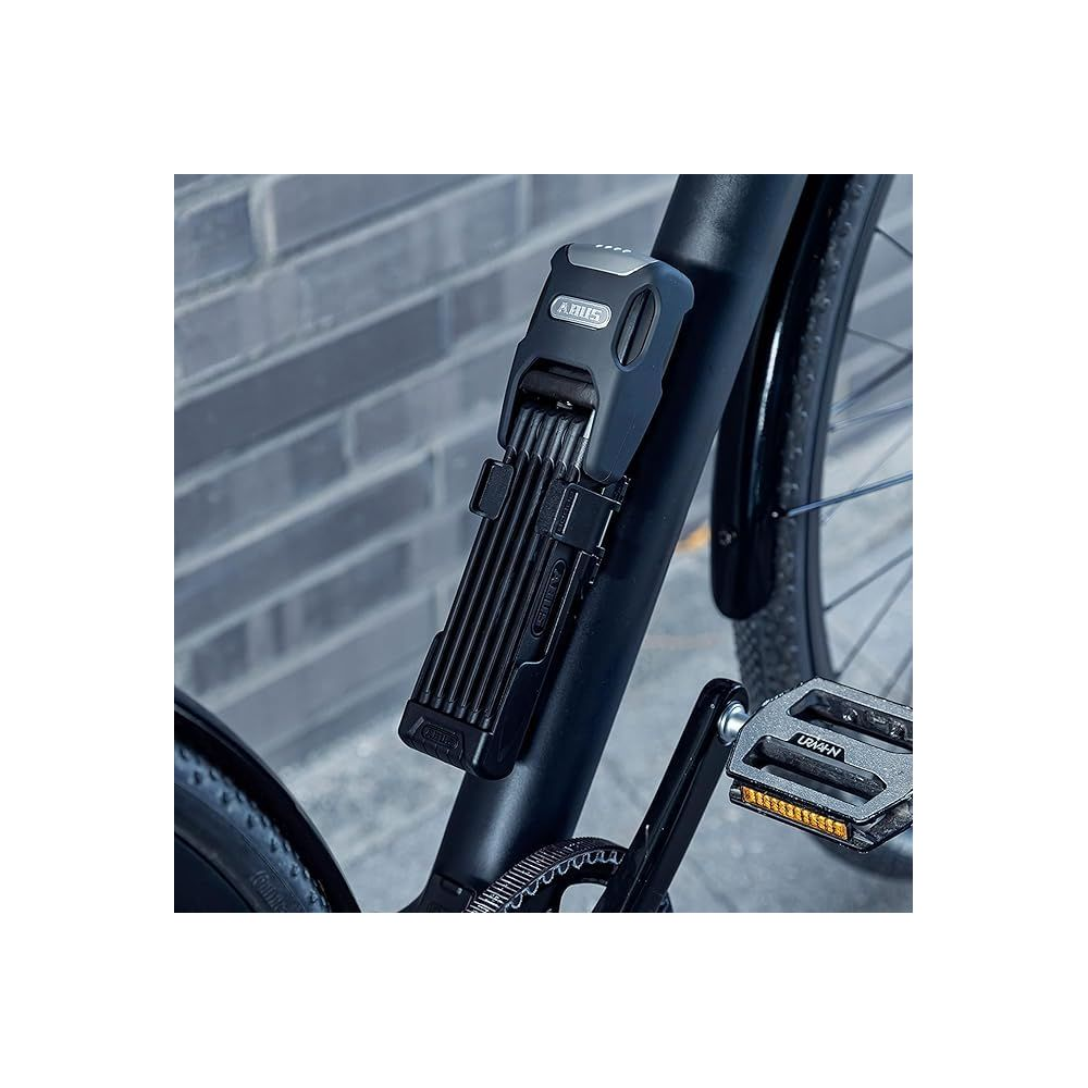 Ein schwarzes Fahrradschloss am Fahrradrahmen, mit Pedal und Kette im Vordergrund.