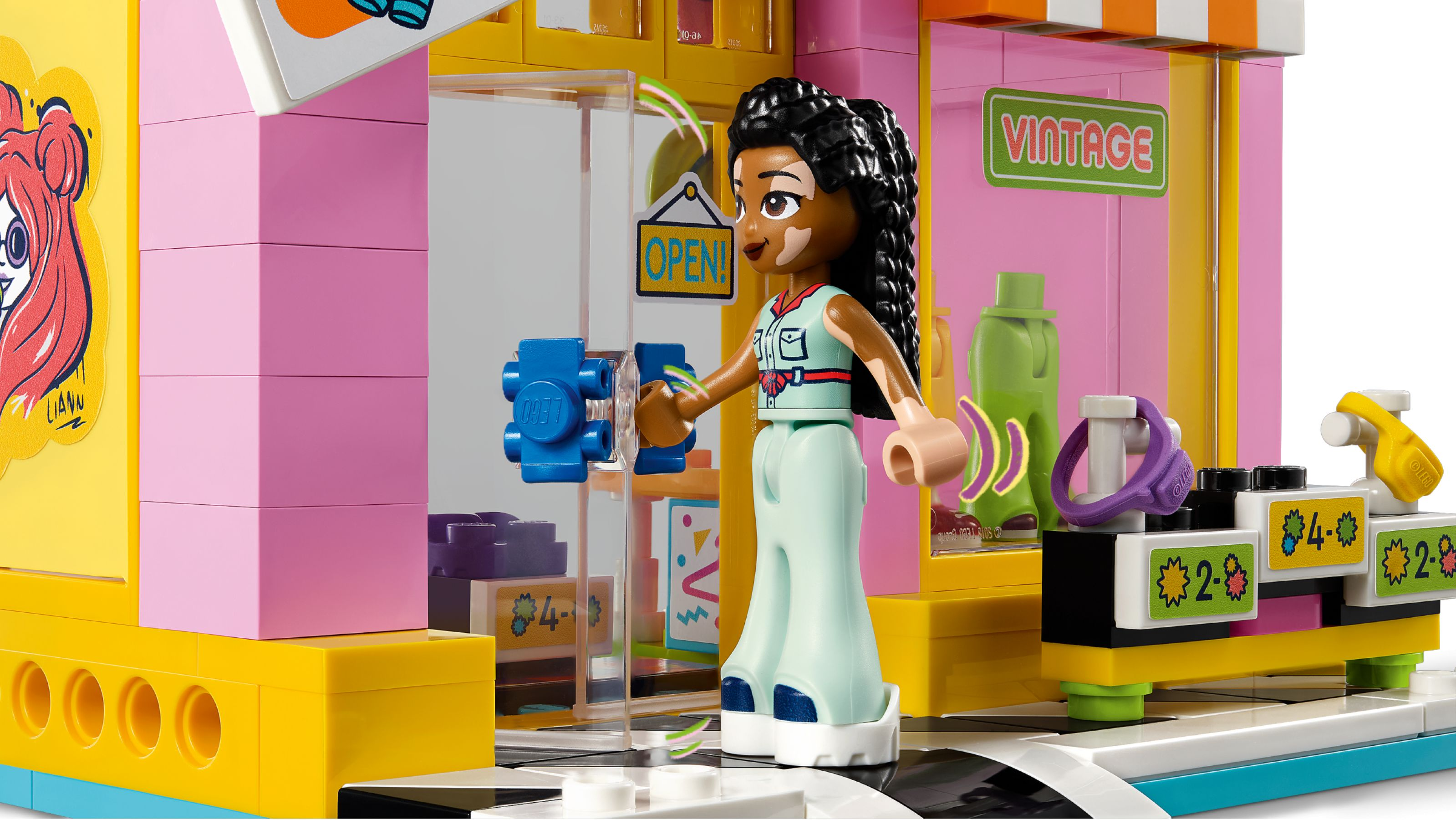Eine Minifigur mit Vitiligo steht vor einem bunten LEGO-Laden mit einem "OPEN!"-Schild.