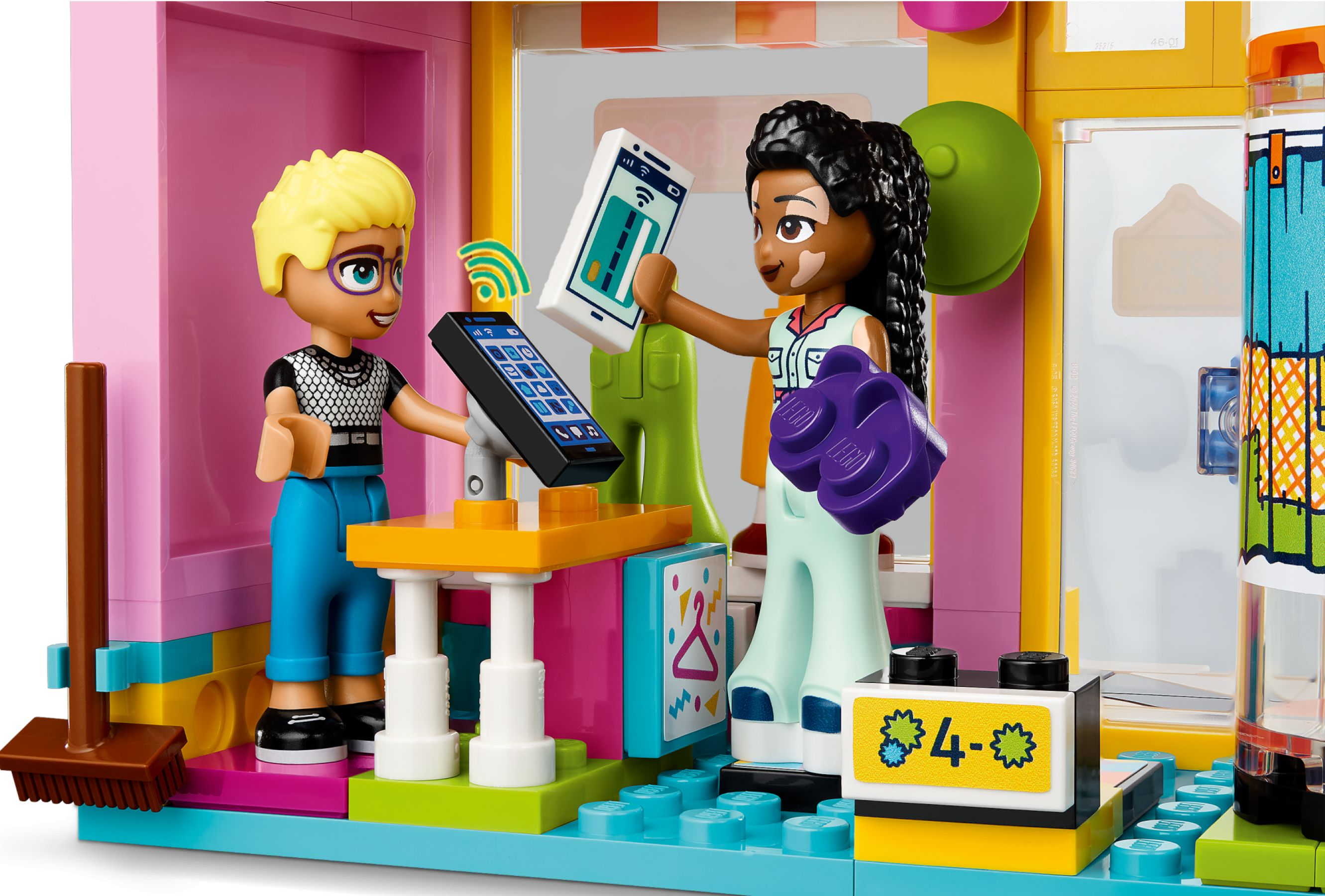 Zwei Lego-Figuren interagieren mit Smartphones in einem bunten Laden.