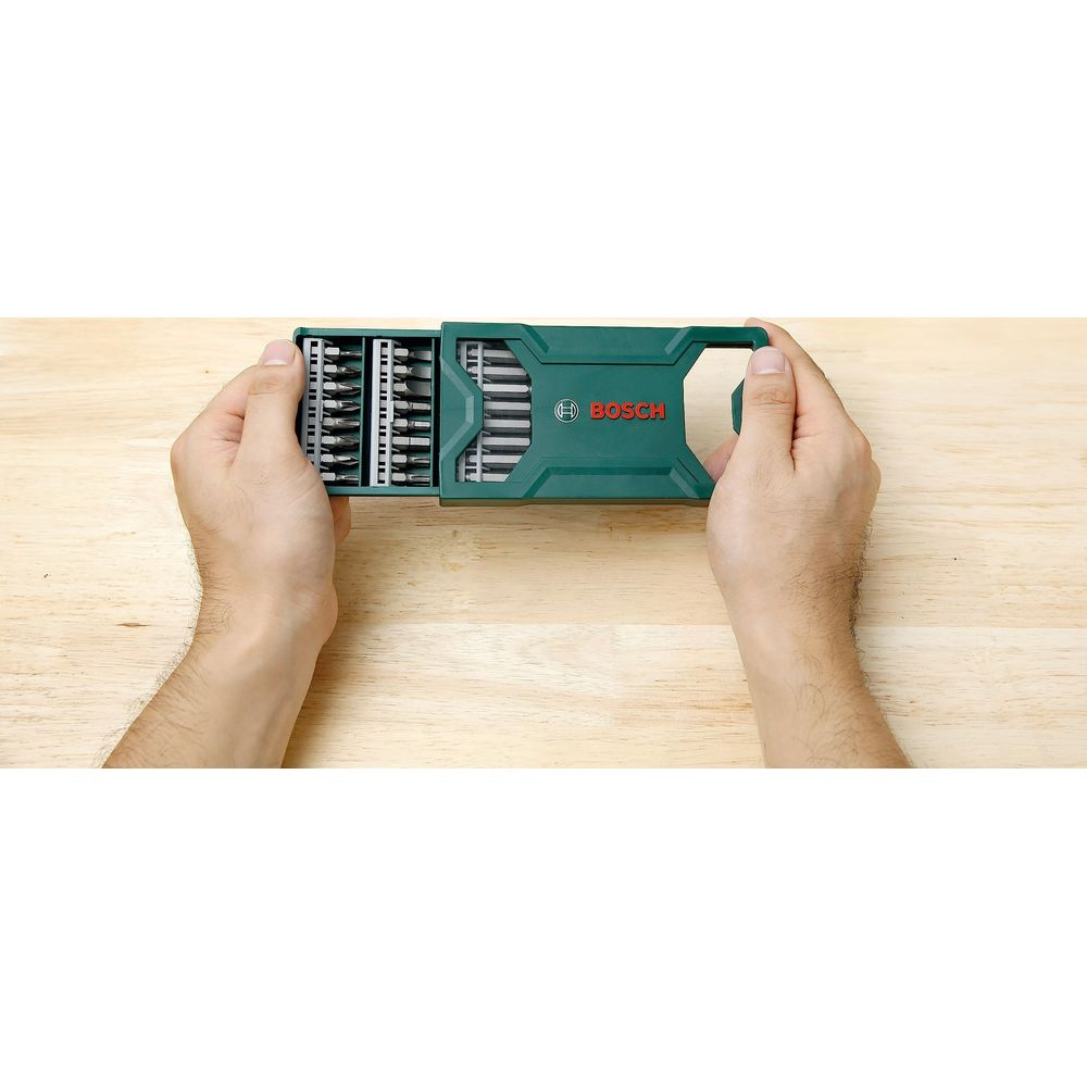 Hände halten eine grüne Bosch-Bitbox mit vielen Bits.