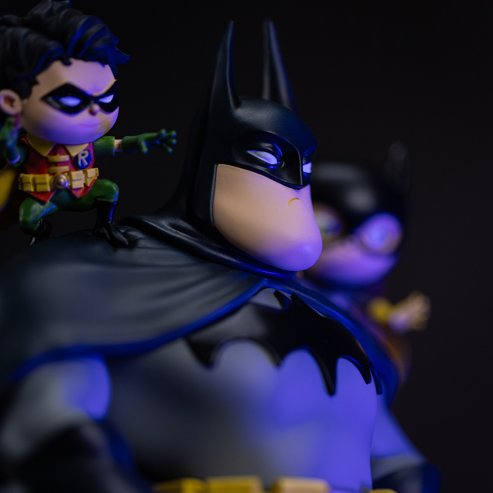 Batman-Figur mit Robin auf der Schulter, im Hintergrund eine weitere Figur.
