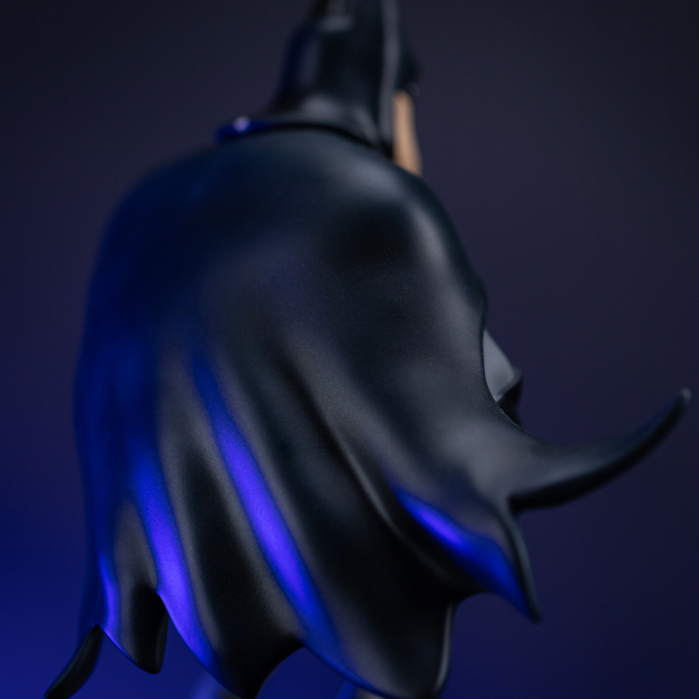 Dunkle Kapuze und Cape von Batman mit blauen Lichtern.