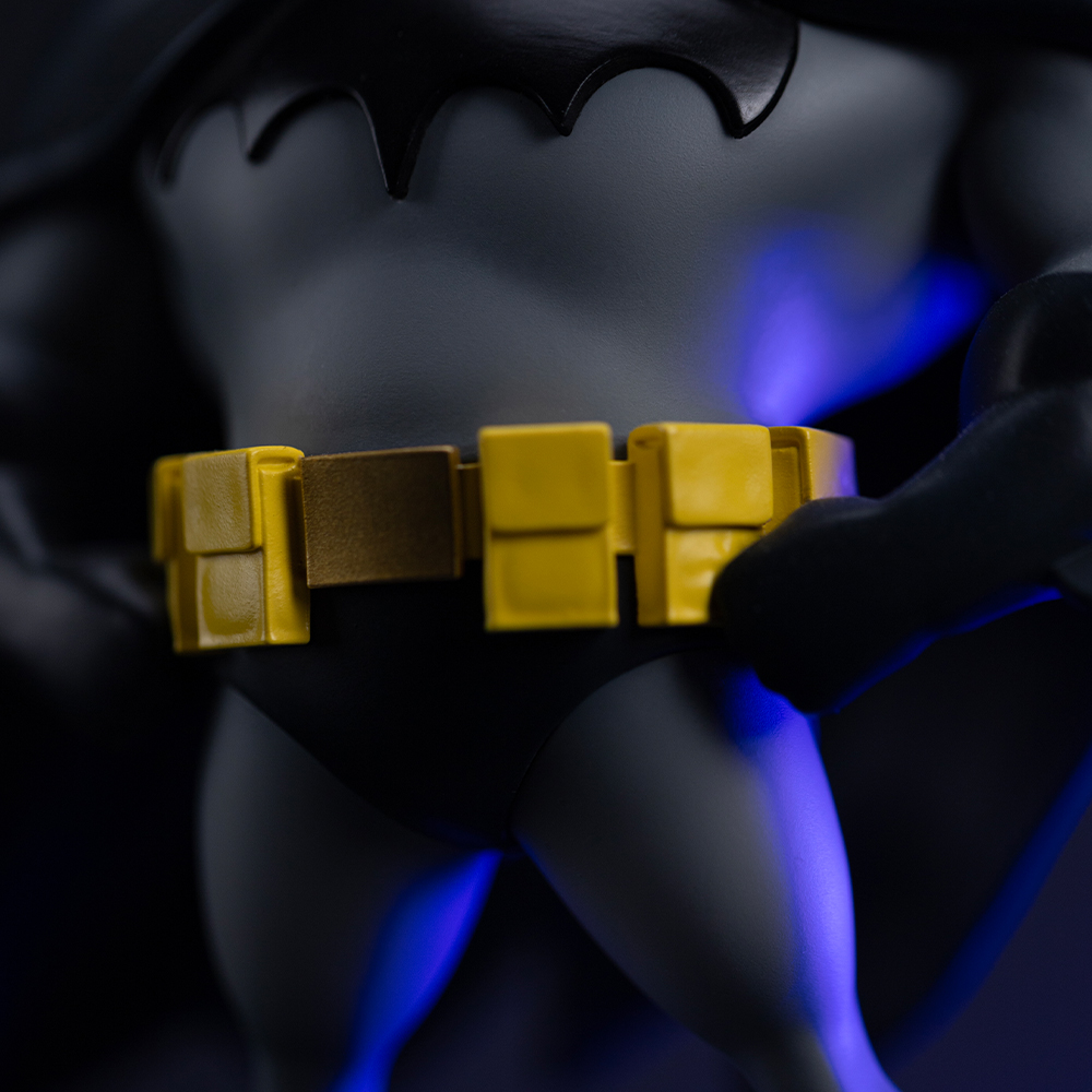 Nahaufnahme von Batmans gelbem Gürtel und dunklem Anzug, mit blauer Beleuchtung.