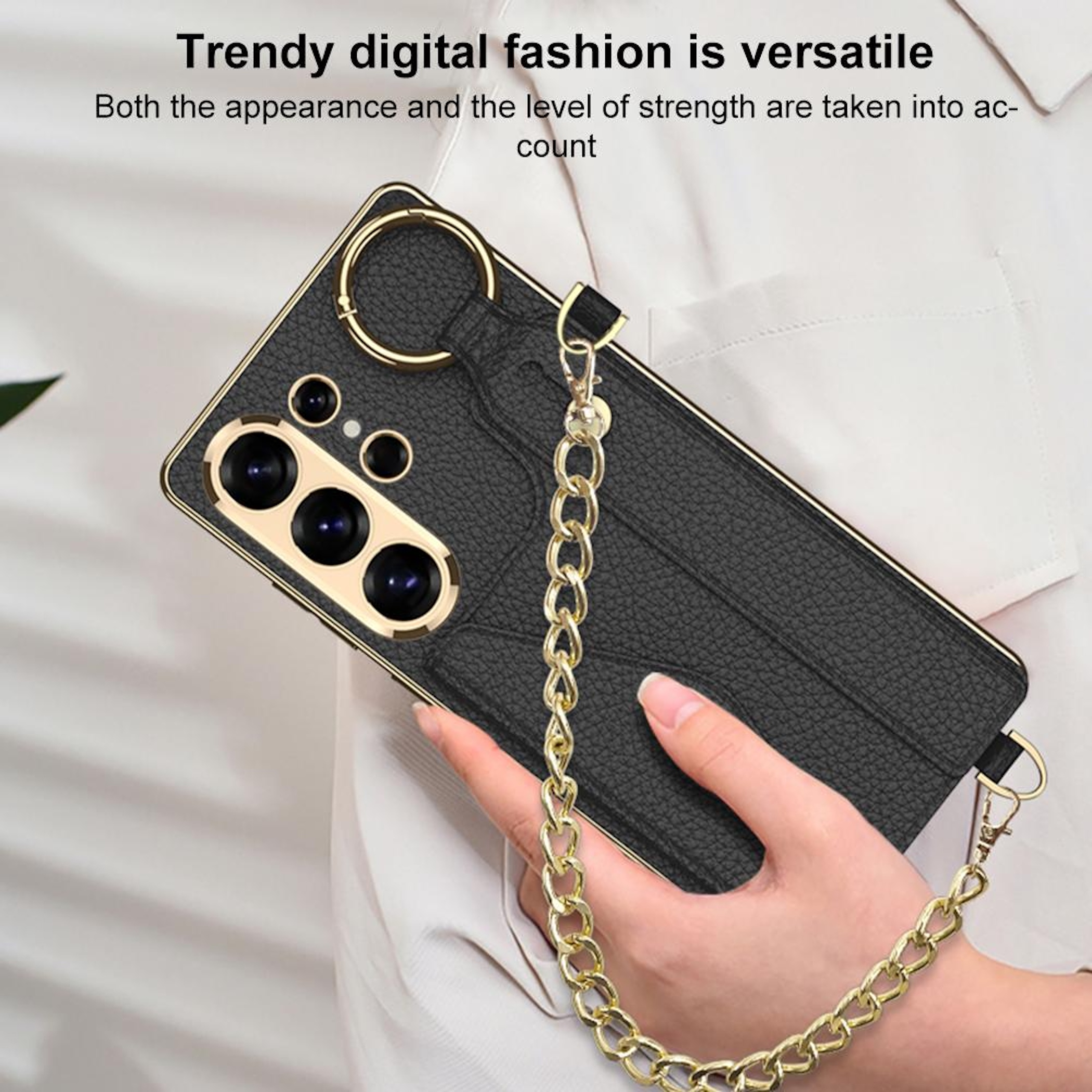 Schwarze Handyhülle mit Goldkette und Ringhalter, in Hand gehalten.