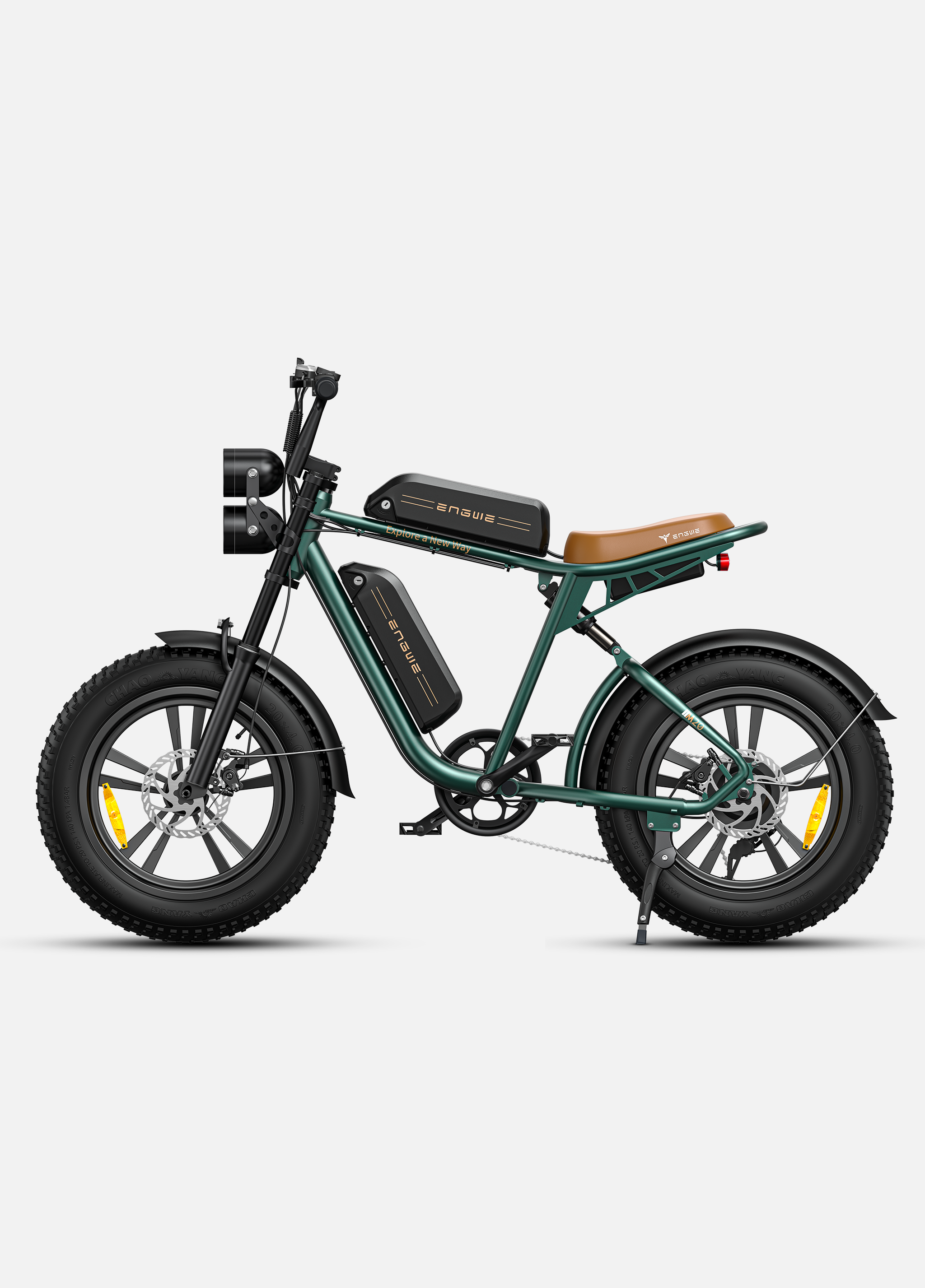 Bicicleta eléctrica verde con sillín marrón, dos baterías y doble faro.