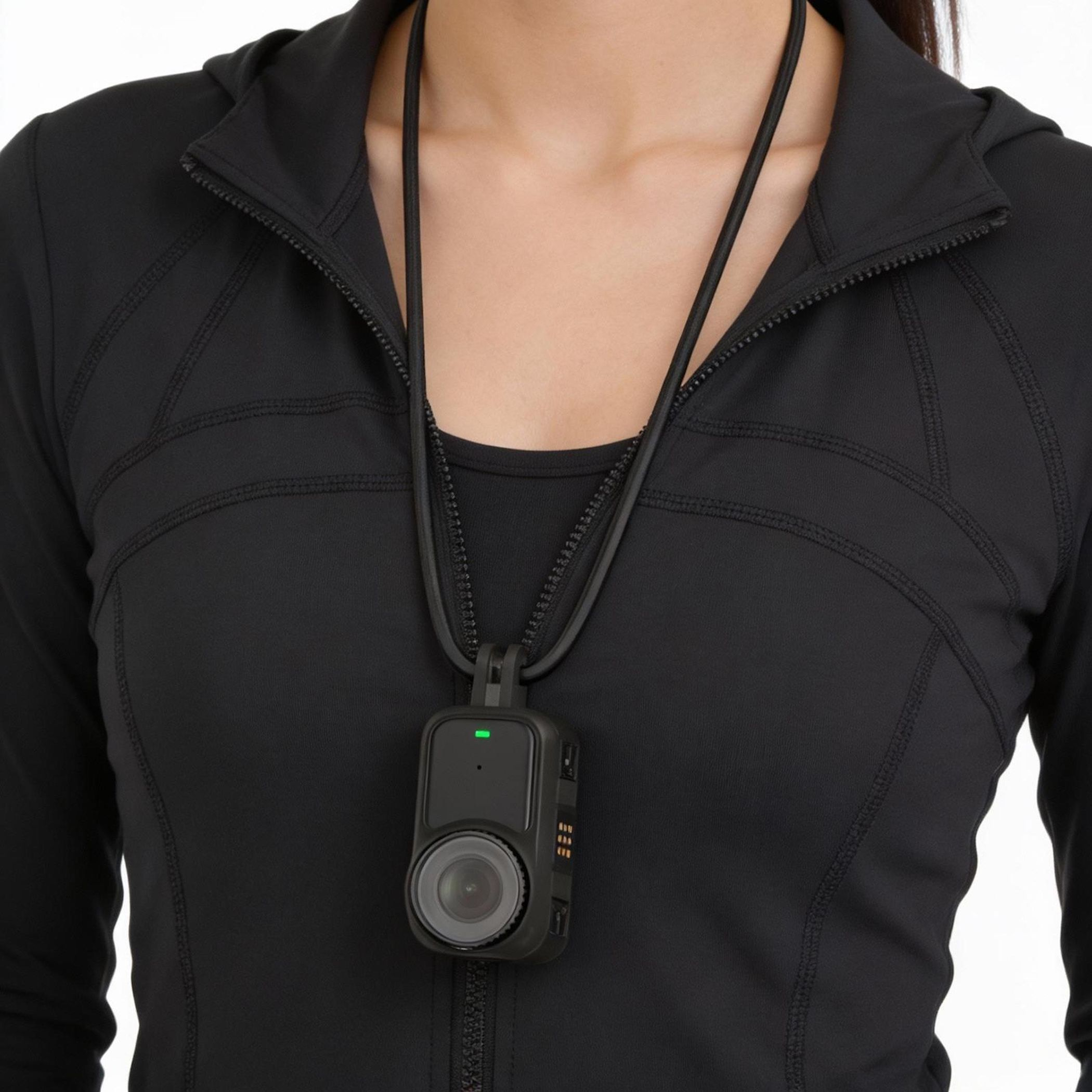 Eine Person trägt eine schwarze Jacke mit einer an einem Band befestigten Kamera.