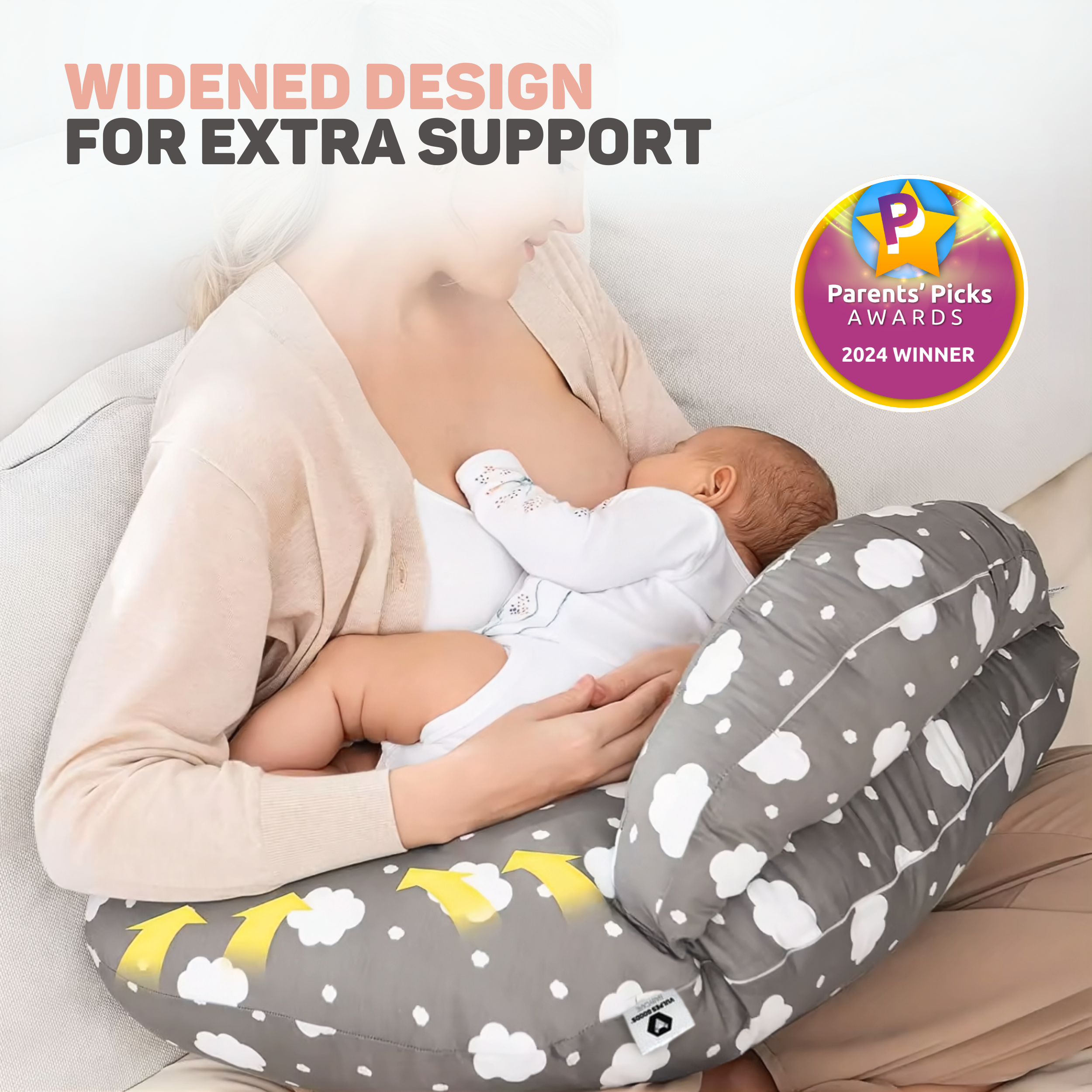 Een vrouw voedt een baby op een kussen met wolkendessin. Winnaar 2024.