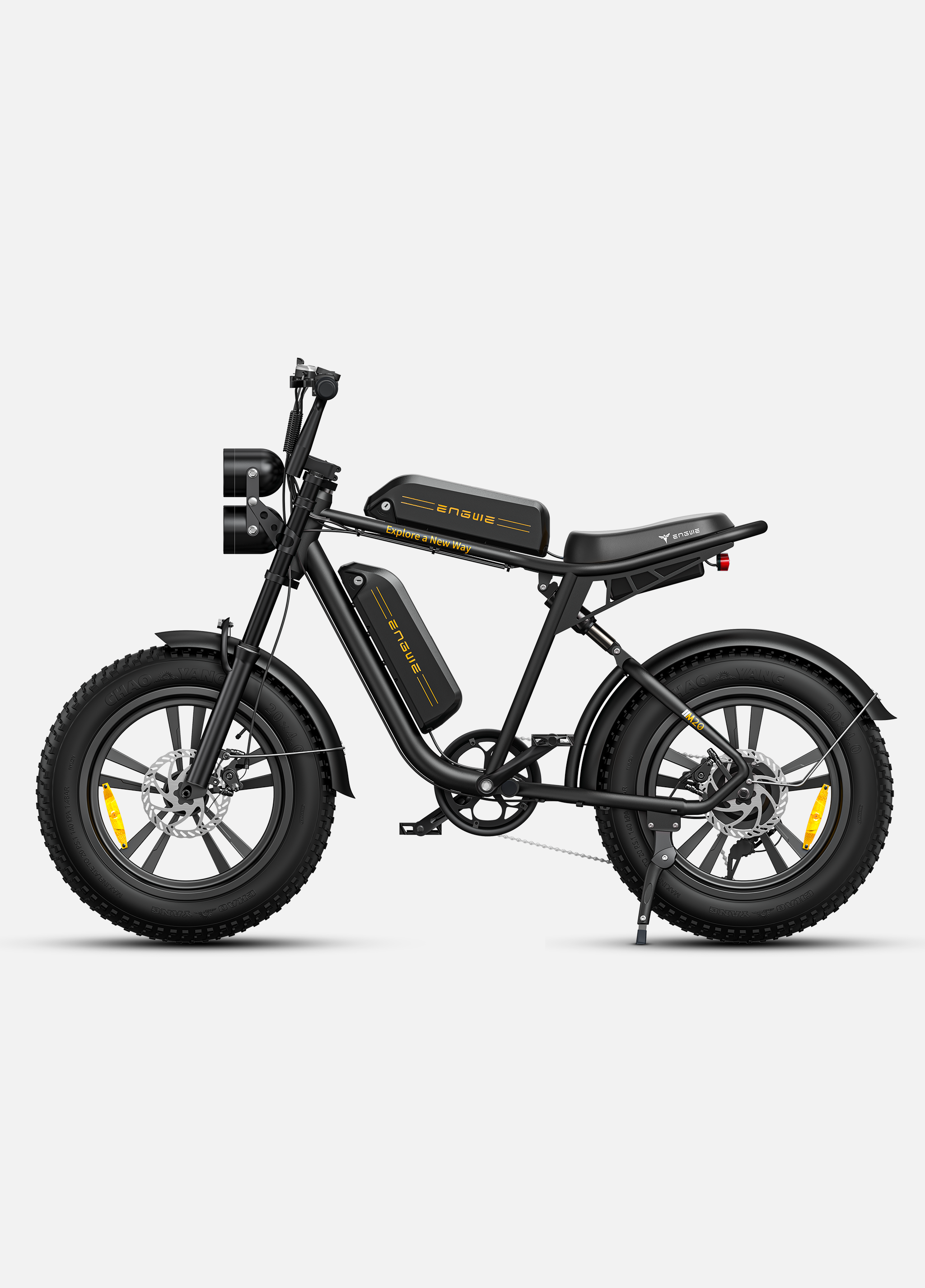 Bicicleta eléctrica negra con llantas anchas, doble faro y dos baterías.