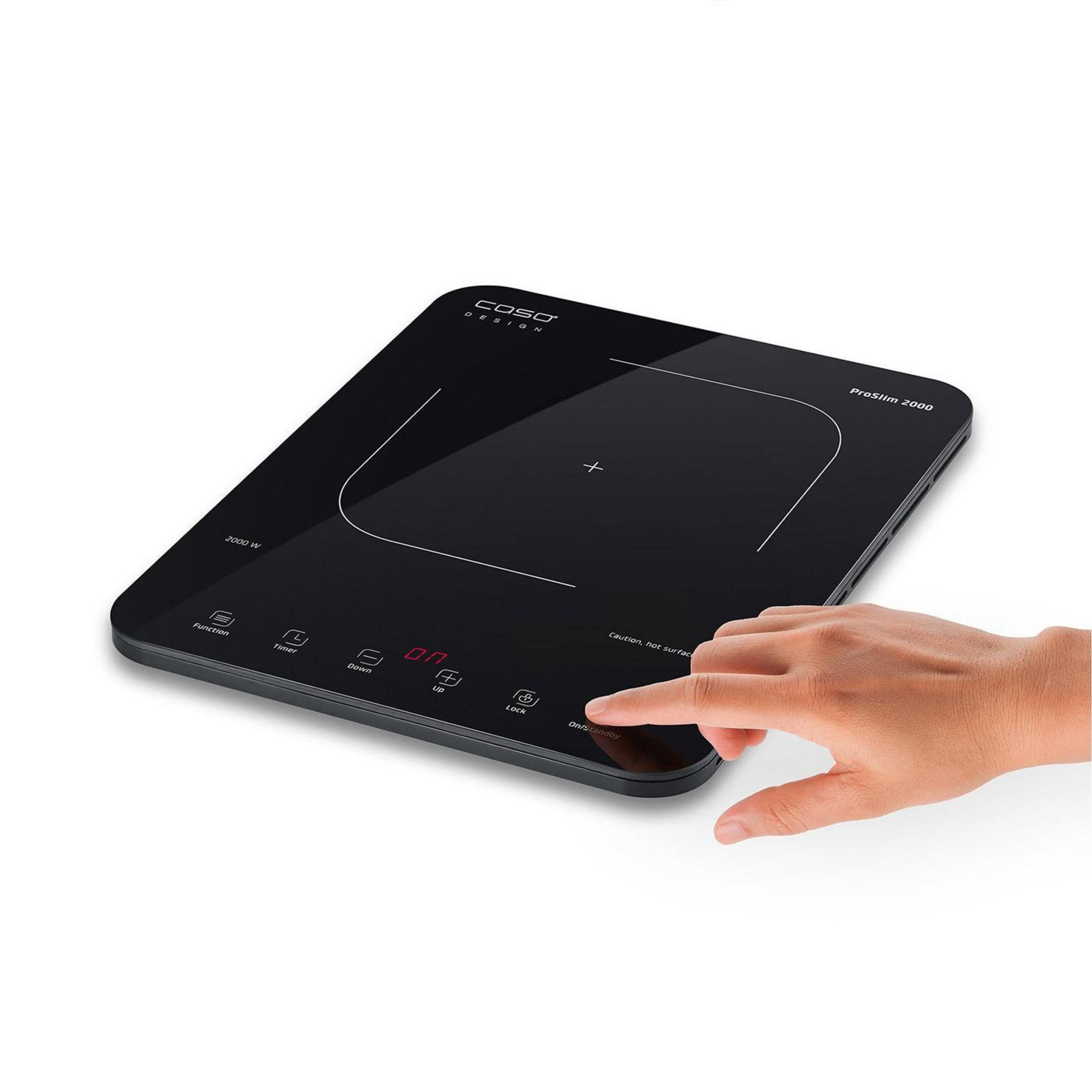 Eine Hand bedient ein schwarzes Induktionskochfeld mit digitalen Anzeigen und Tasten.