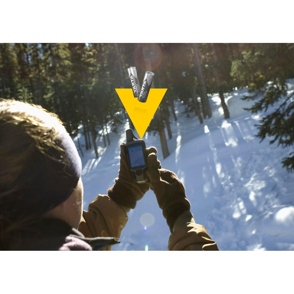 Person holding GPS in snow, Varta batteries above.