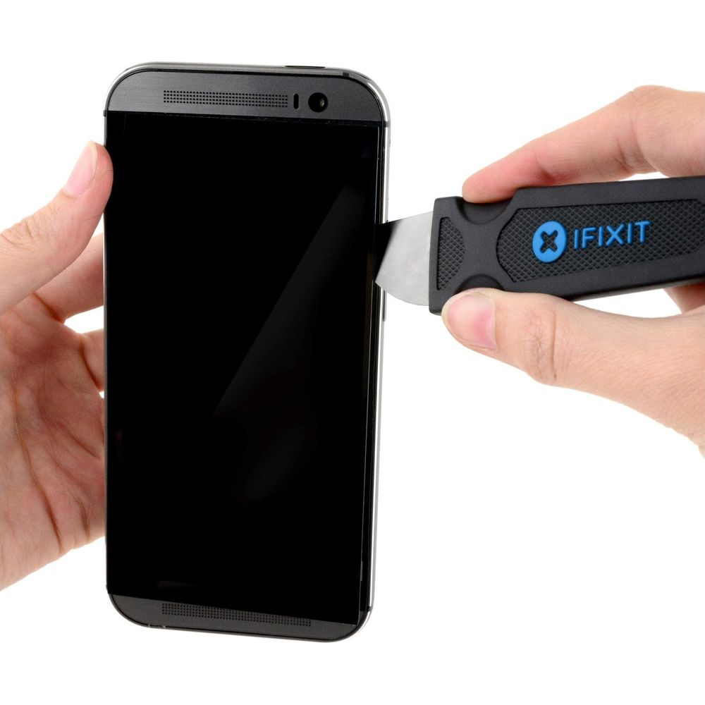 Eine Hand hält ein Smartphone, eine andere Hand benutzt ein iFixit-Werkzeug zum Öffnen.