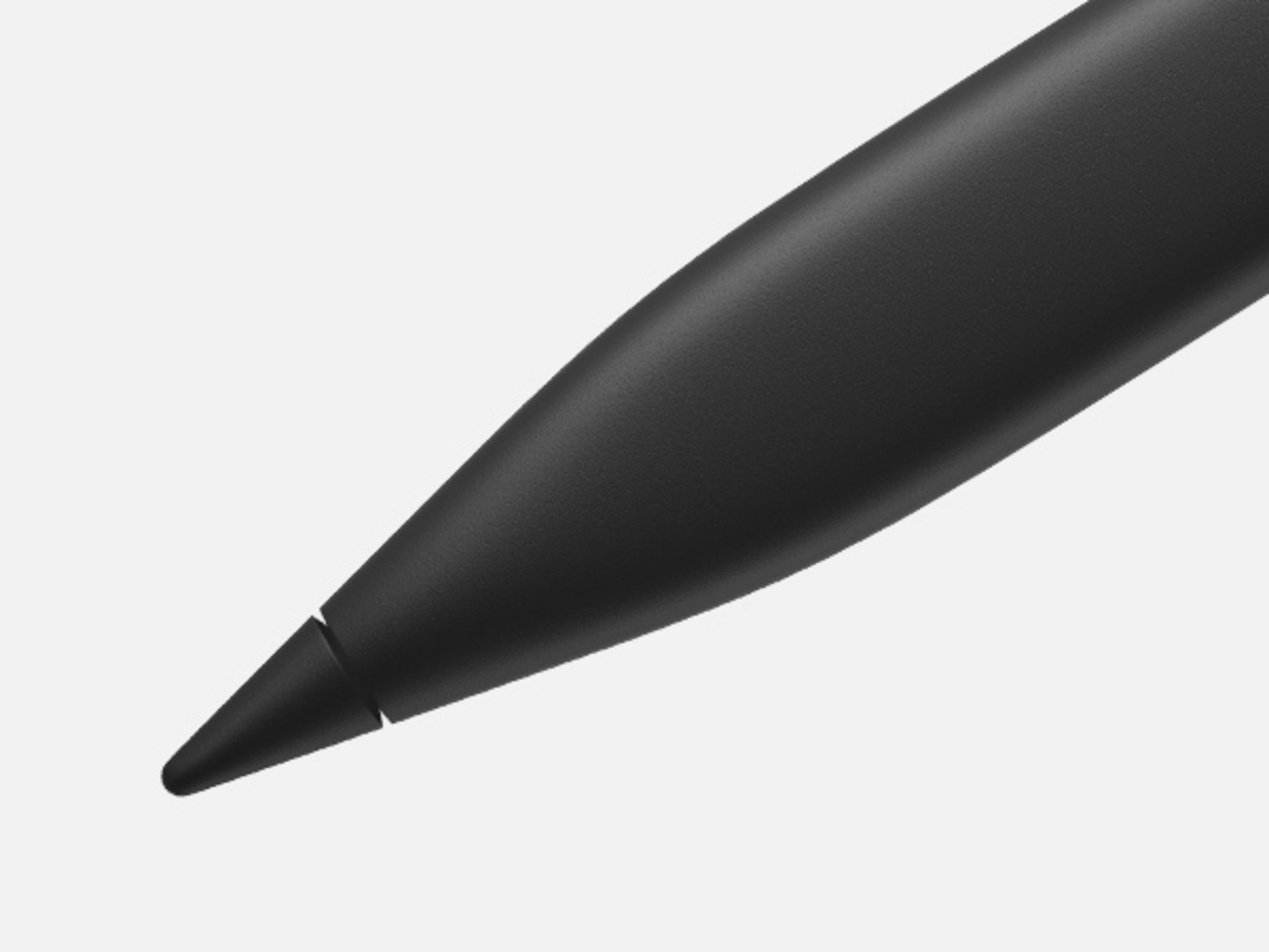 Zbliżenie czubkiem czarnego długopisu na szarym tle.