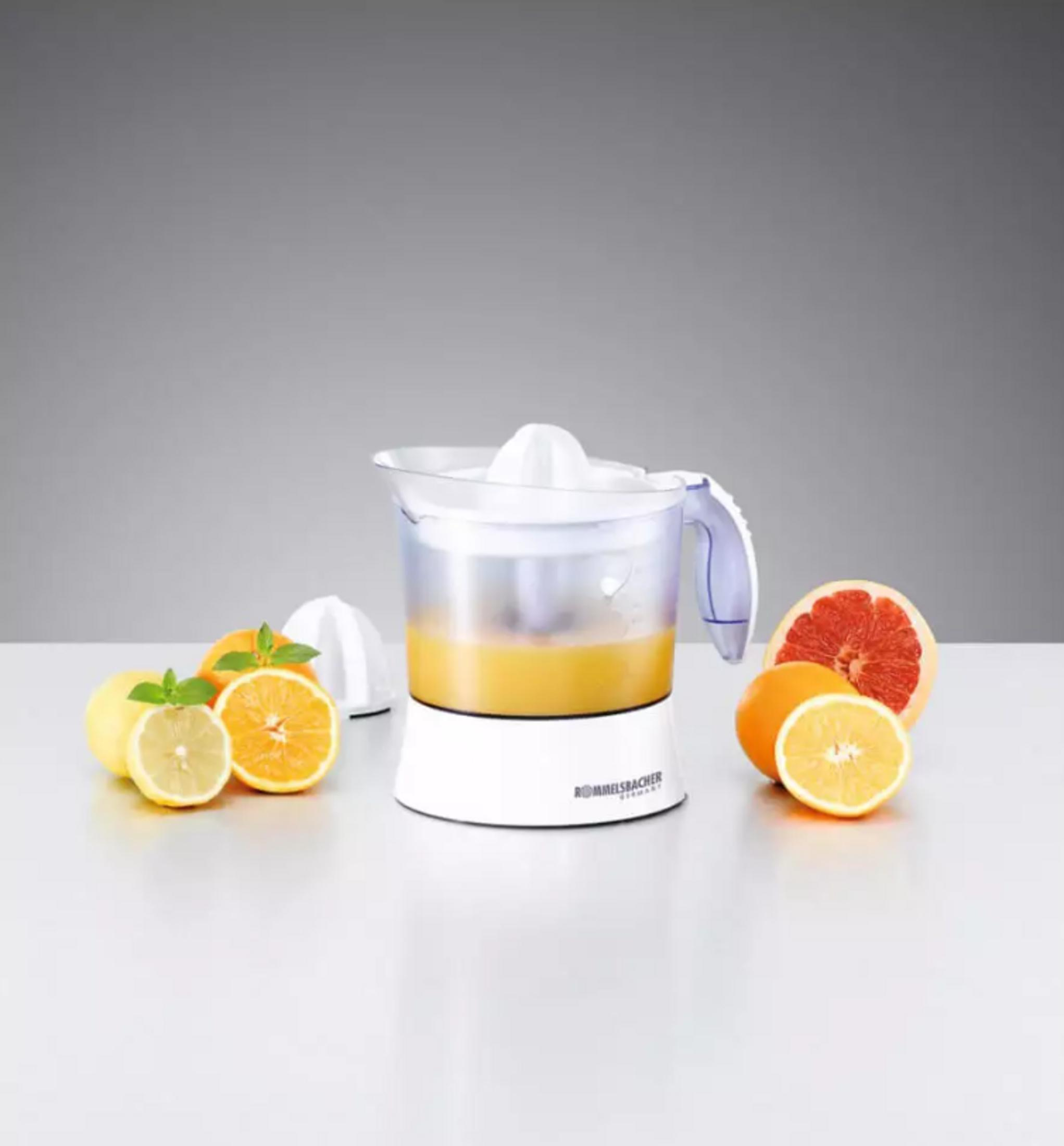 Un spremiagrumi elettrico con arance, limoni e pompelmi.