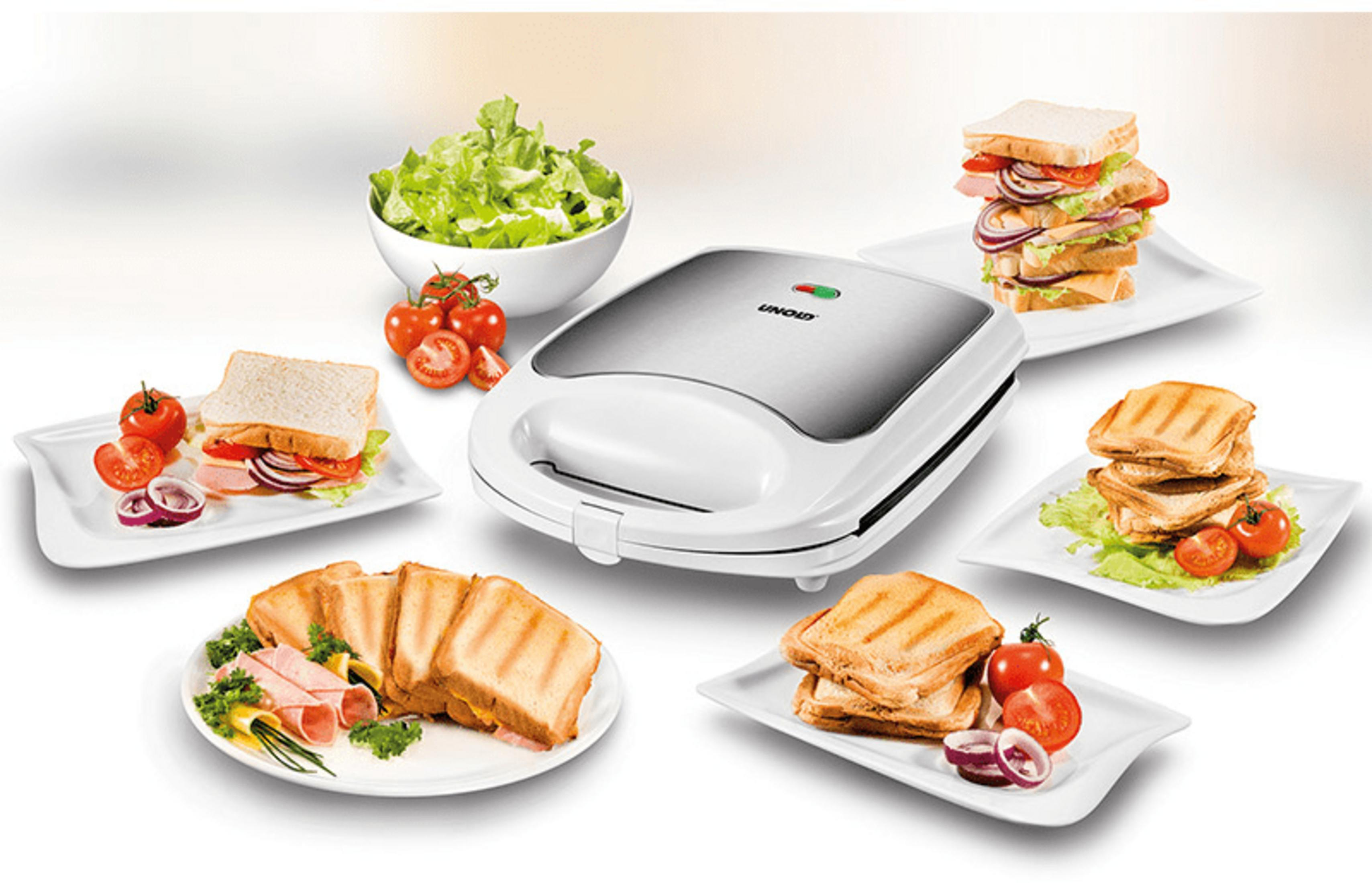 Biała opiekacz do kanapek z kanapkami, sałatką i pomidorami.