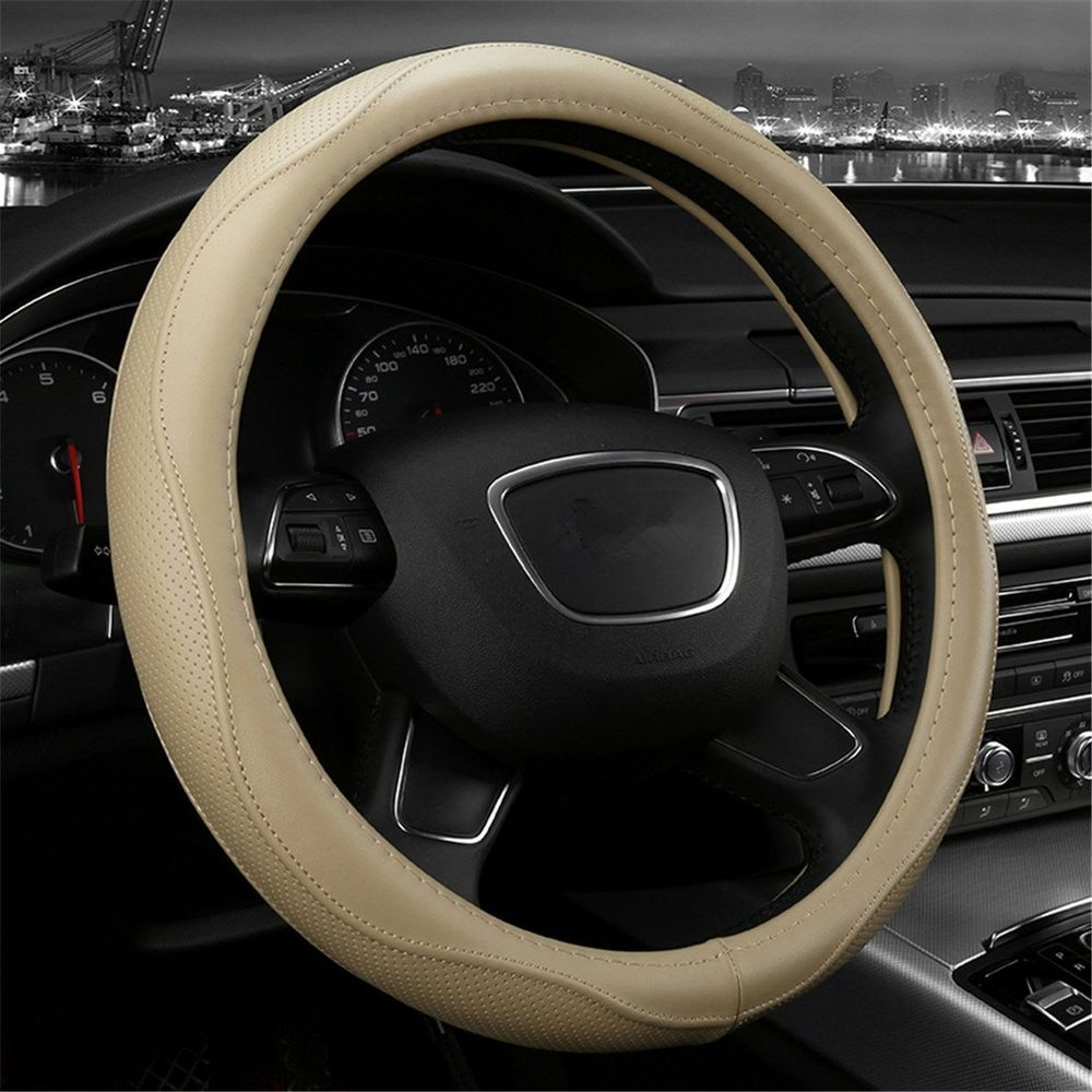 Coprivolante beige su volante nero all'interno di un'auto.