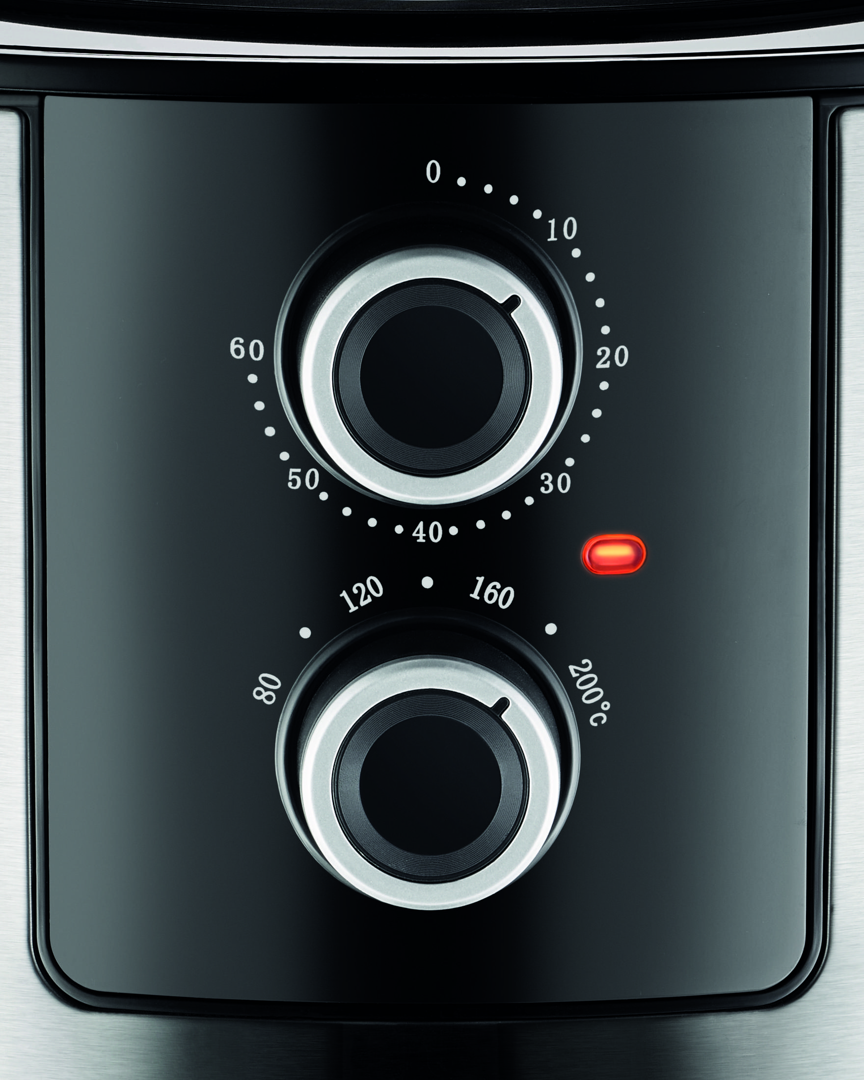 Zbliżenie dwóch pokręteł sterujących ze skalą i pomarańczową lampką kontrolną.