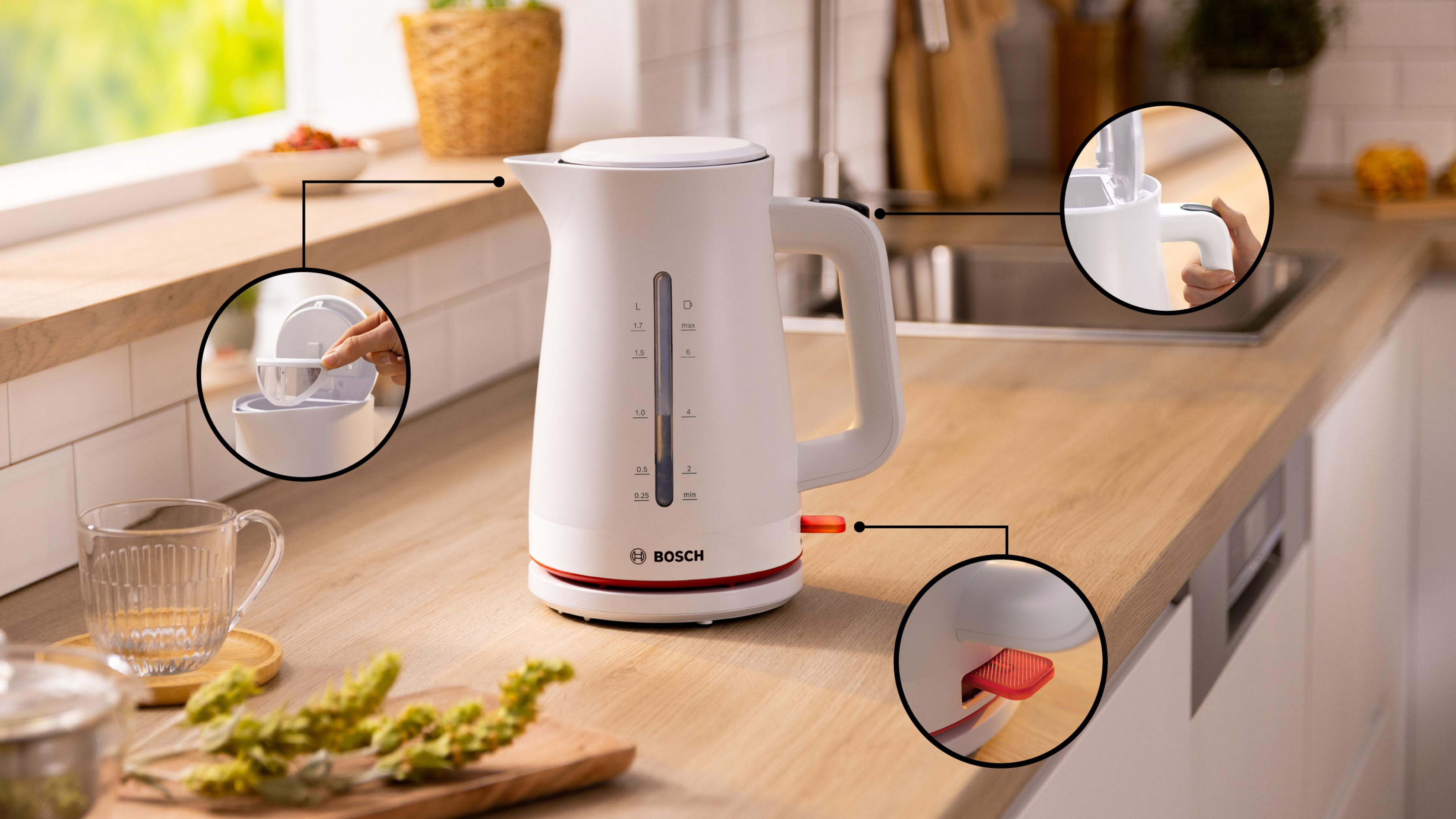 Biały czajnik elektryczny z czerwonymi akcentami na drewnianym blacie.