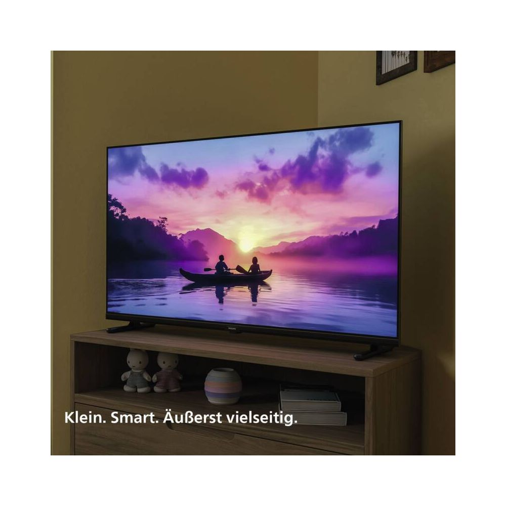 Telewizor wyświetla obraz dwóch osób w kajaku o zachodzie słońca na wodzie.