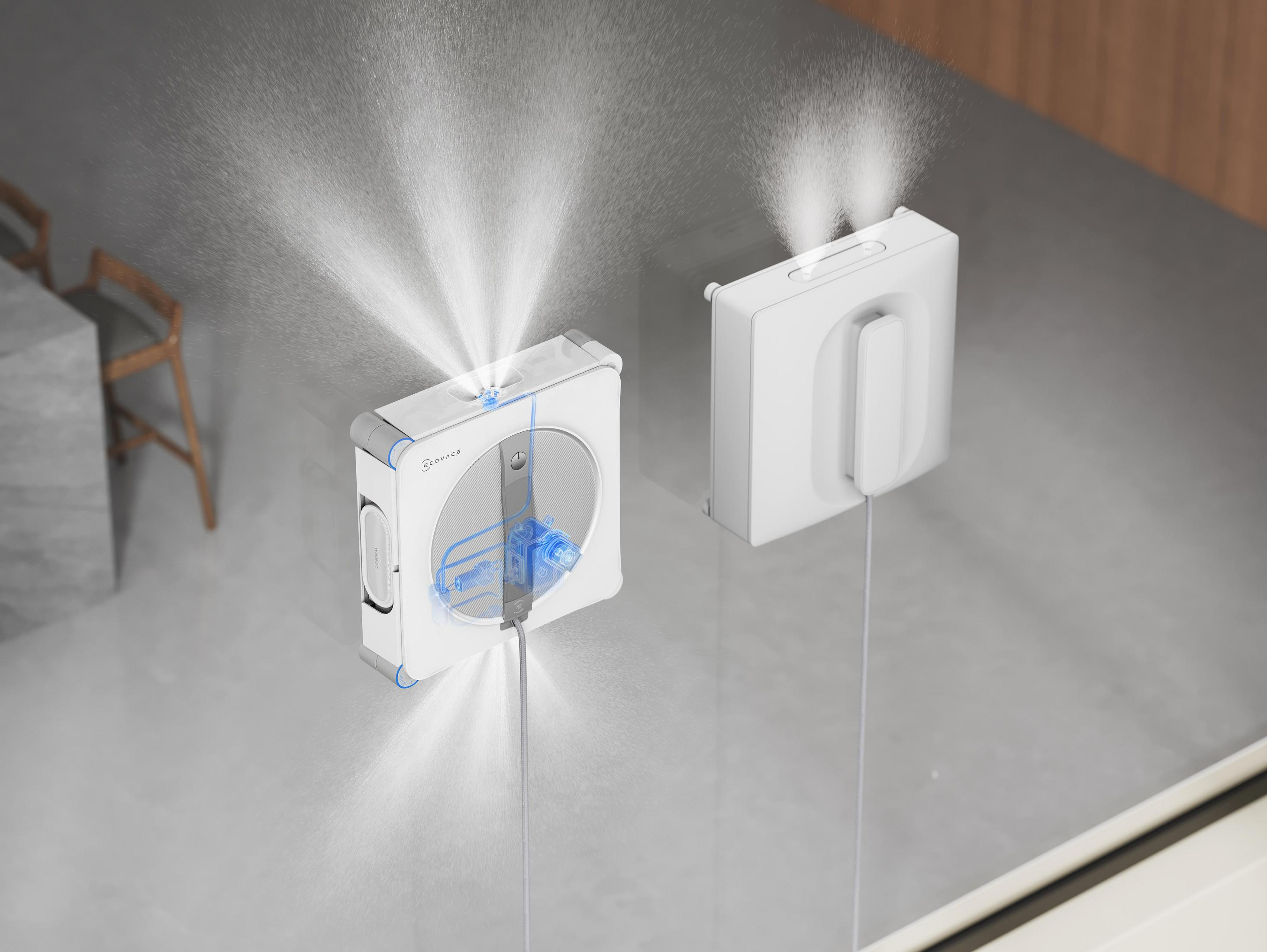 Dwa białe roboty rozpylają wodę na szklaną powierzchnię.