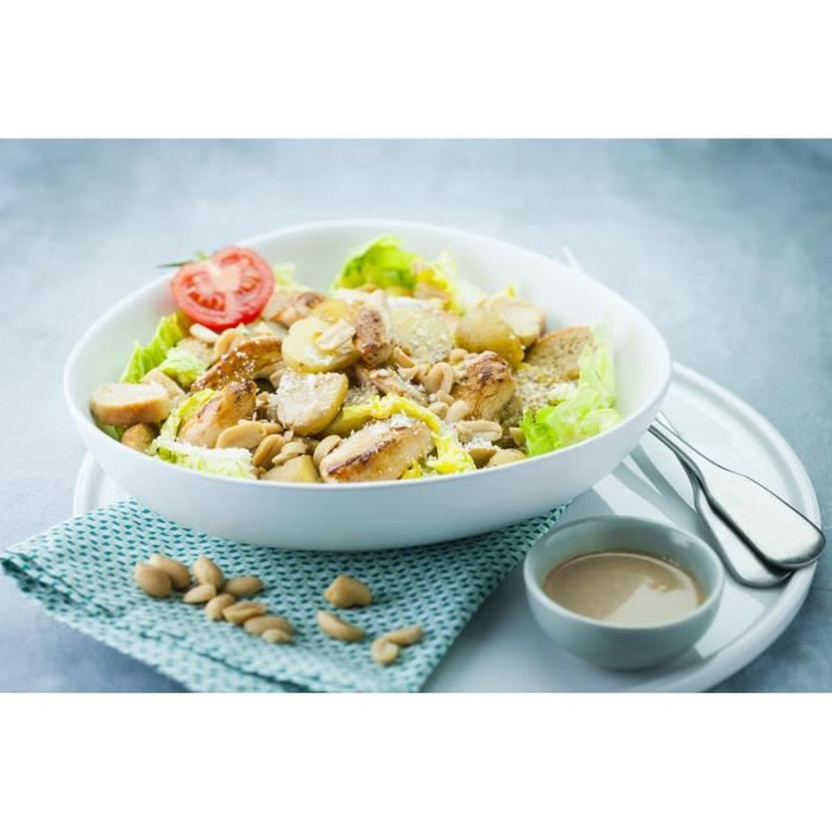 Hähnchensalat mit Kartoffeln, Croutons, Nüssen und Tomaten in einer Schüssel.
