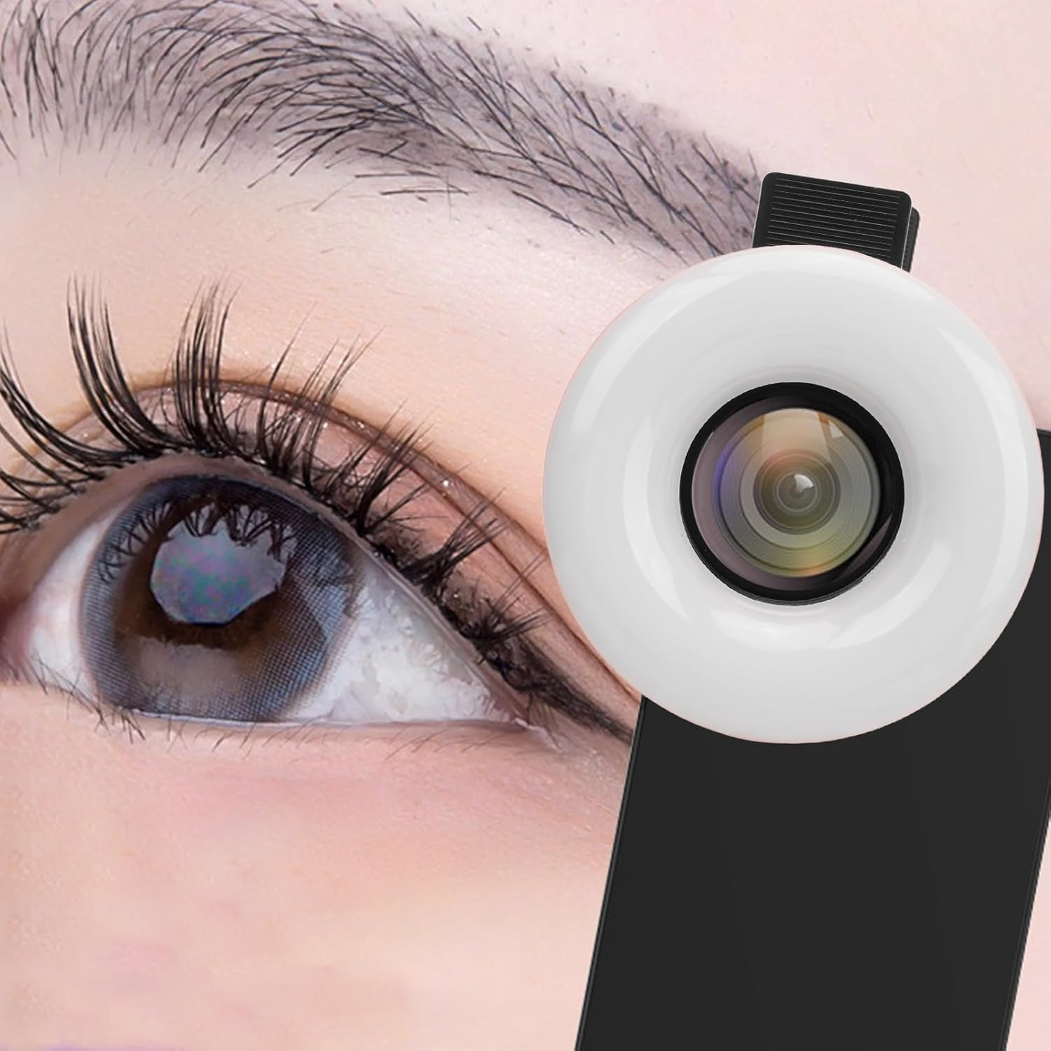 Nahaufnahme eines Auges mit einer Ringlichtkamera, die am Telefon befestigt ist.