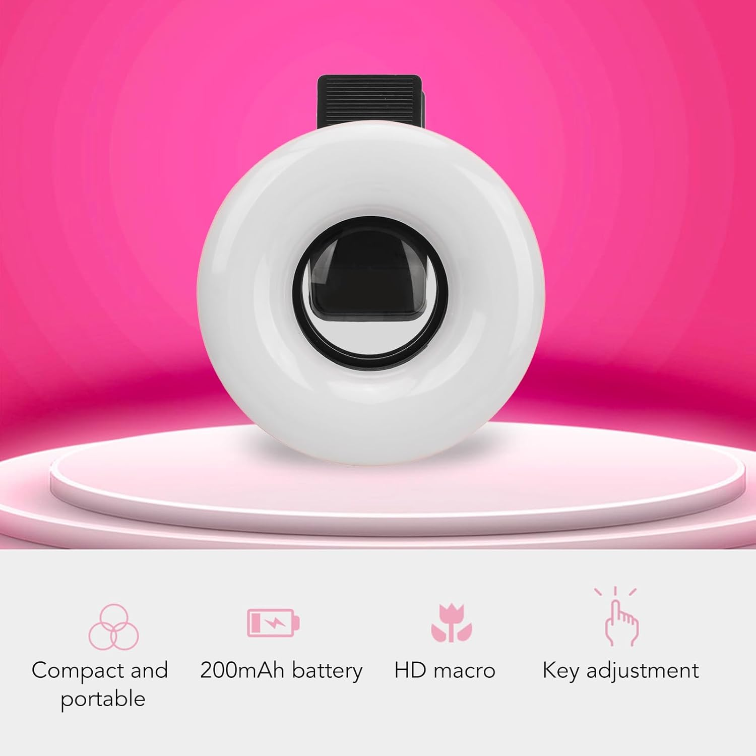 Ein weißes Ringlicht mit schwarzem Clip sitzt auf einem rosa Podest. Icons unten zeigen Funktionen.