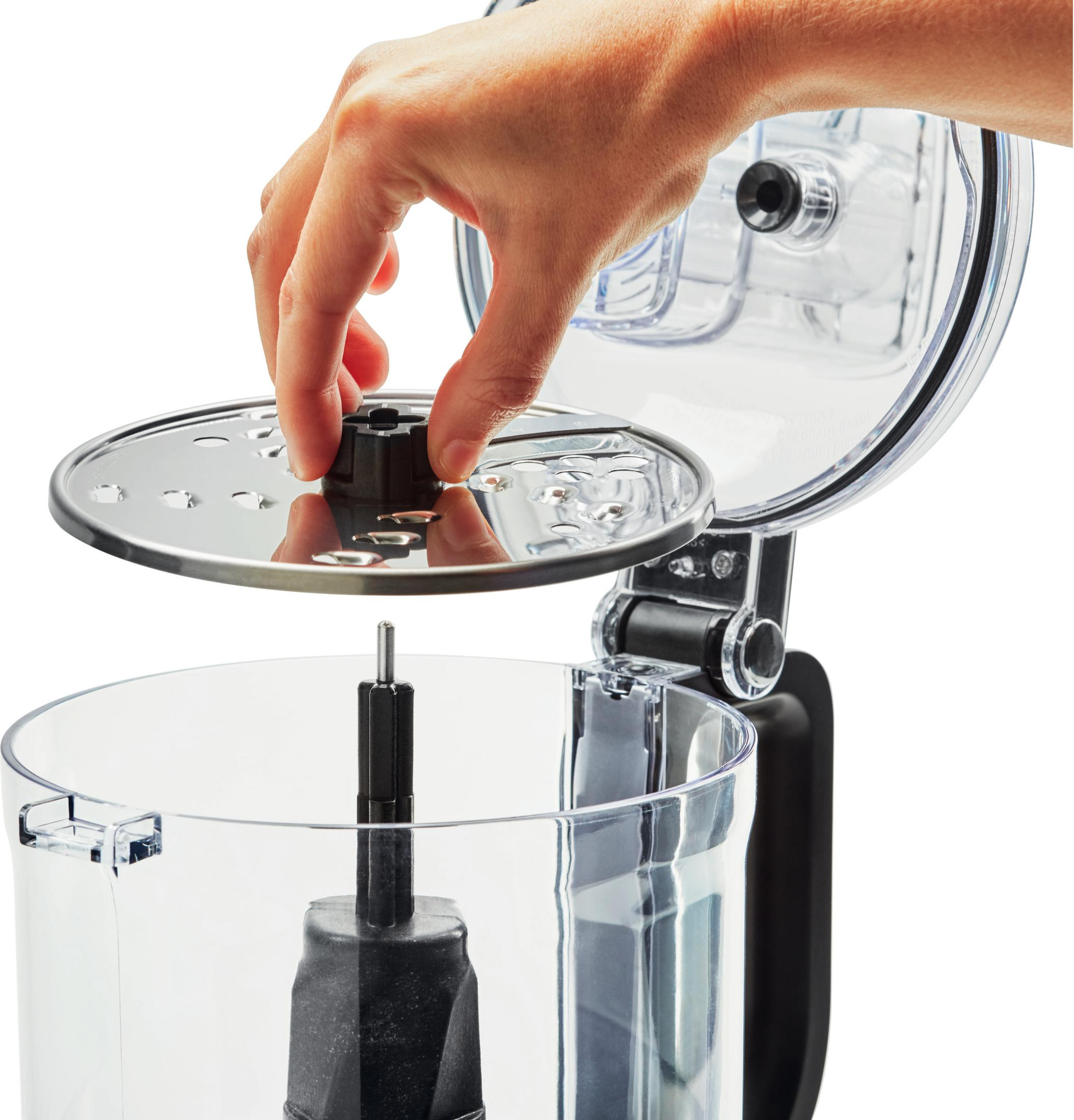 Una mano inserisce un disco nella ciotola di un robot da cucina.