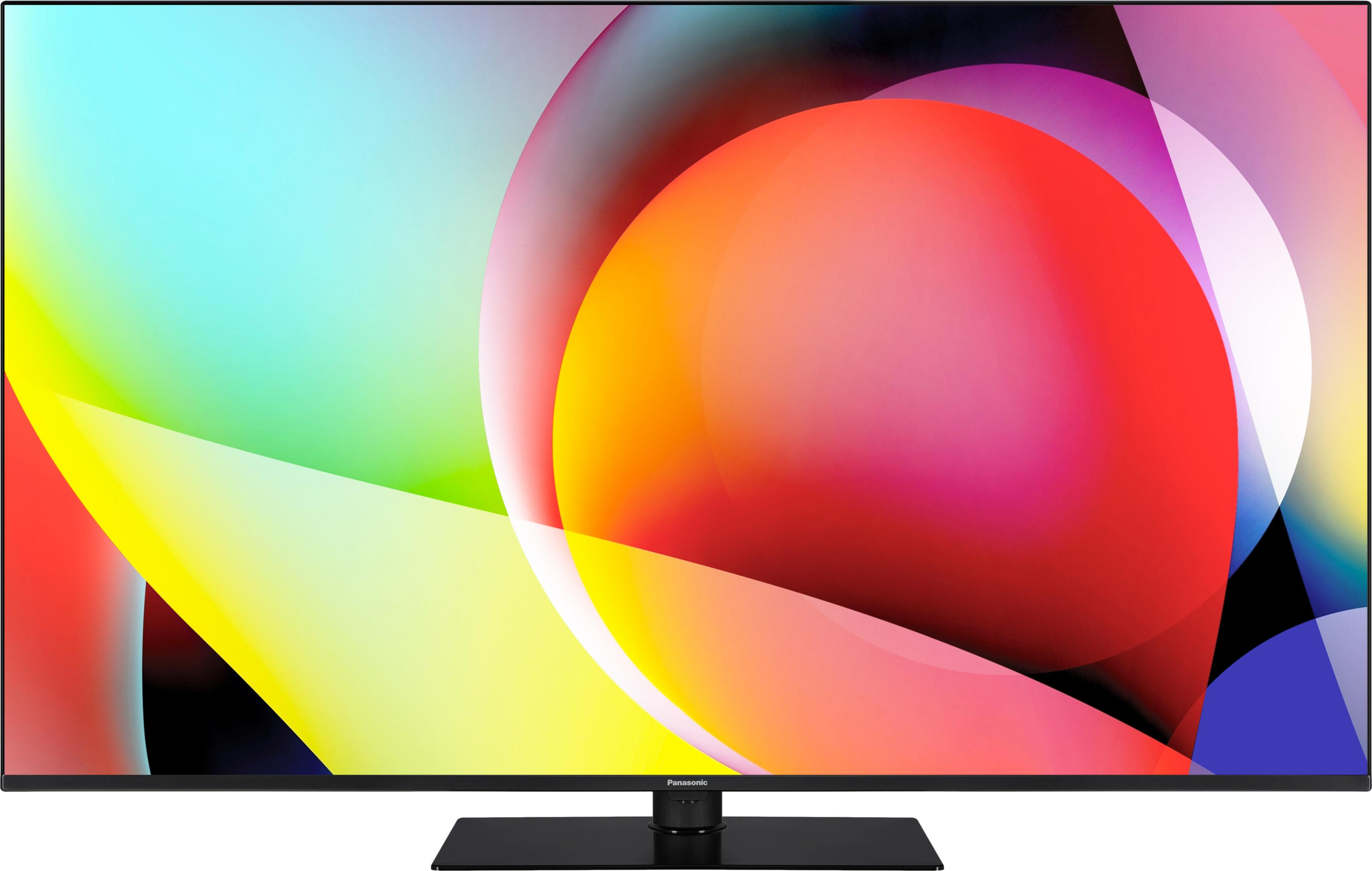 Ekran telewizora wyświetla kolorowe, abstrakcyjne kształty. Na dole znajduje się czarny stojak.