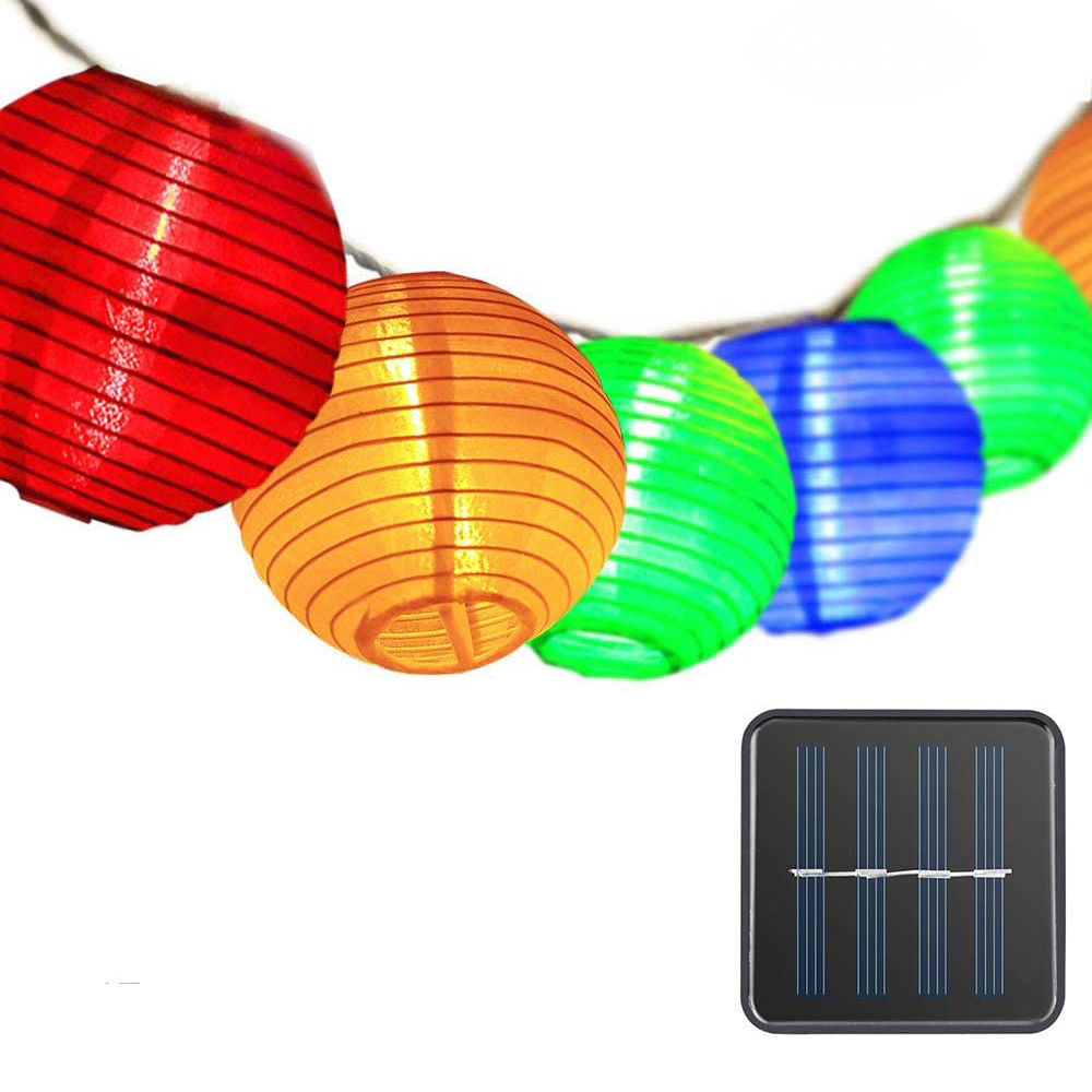 Bunte Lampions und ein Solarpanel auf weißem Hintergrund.