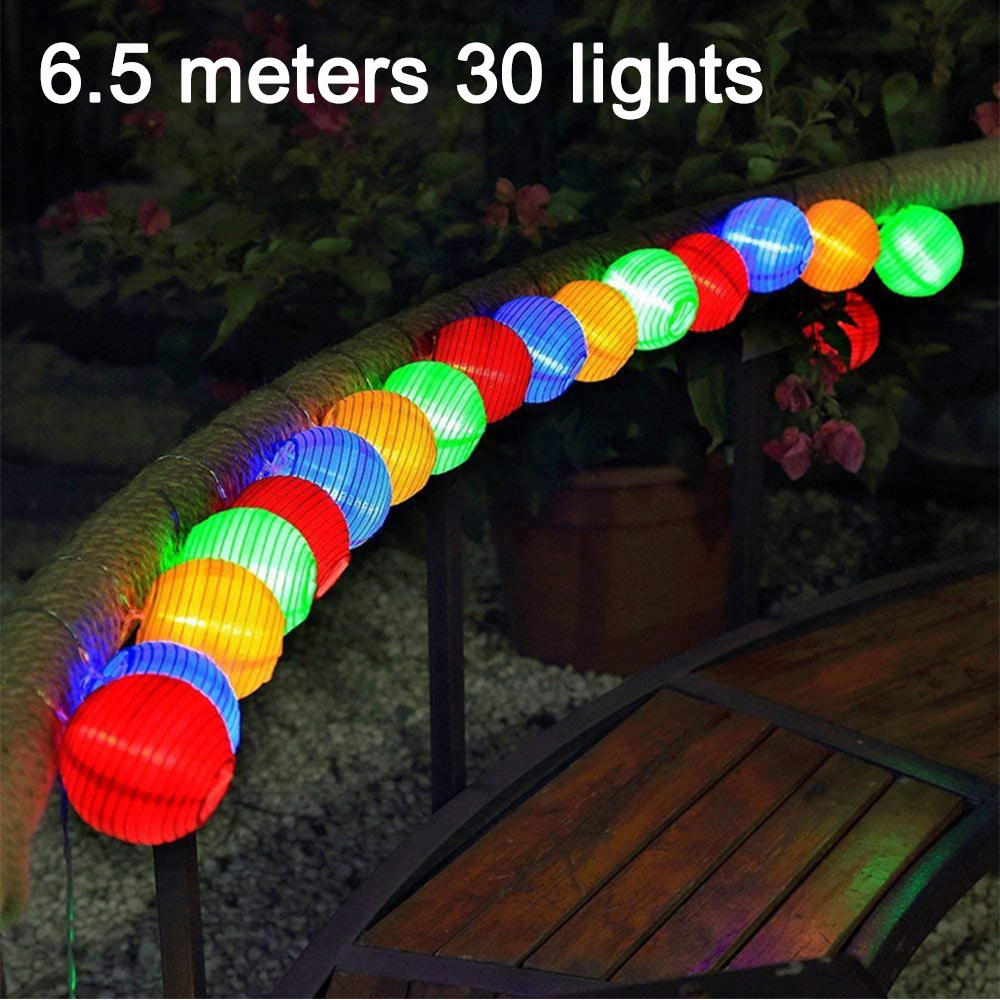 Bunte Lichterkette mit 30 Kugeln, 6,5m lang, auf einem Geländer.