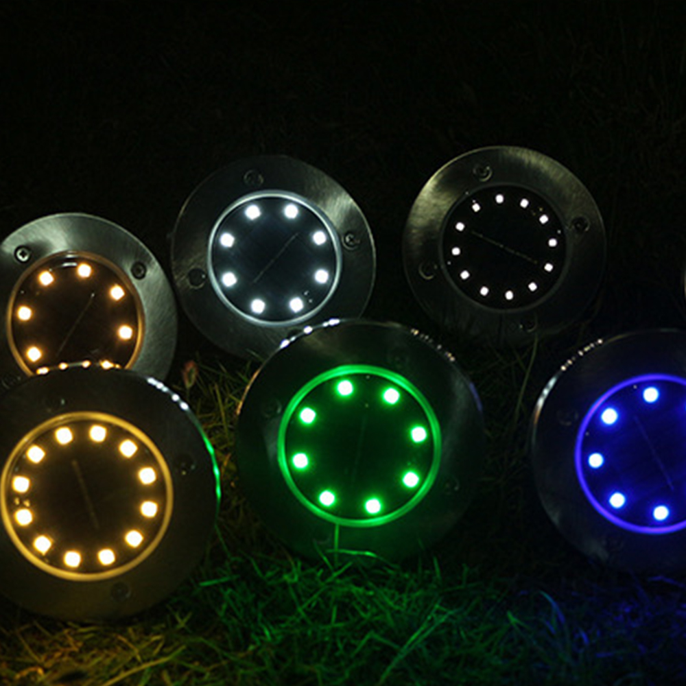 Runde Solarleuchten mit bunten LEDs: gelb, weiß, grün und blau, auf Gras.