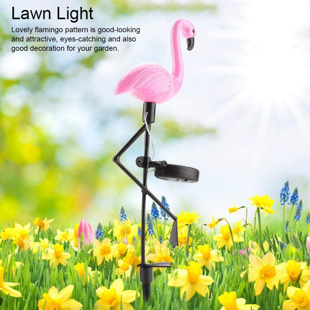 Ein rosa Flamingo-Gartenlicht steht in einem Feld voller gelber Narzissen und blauer Blumen.