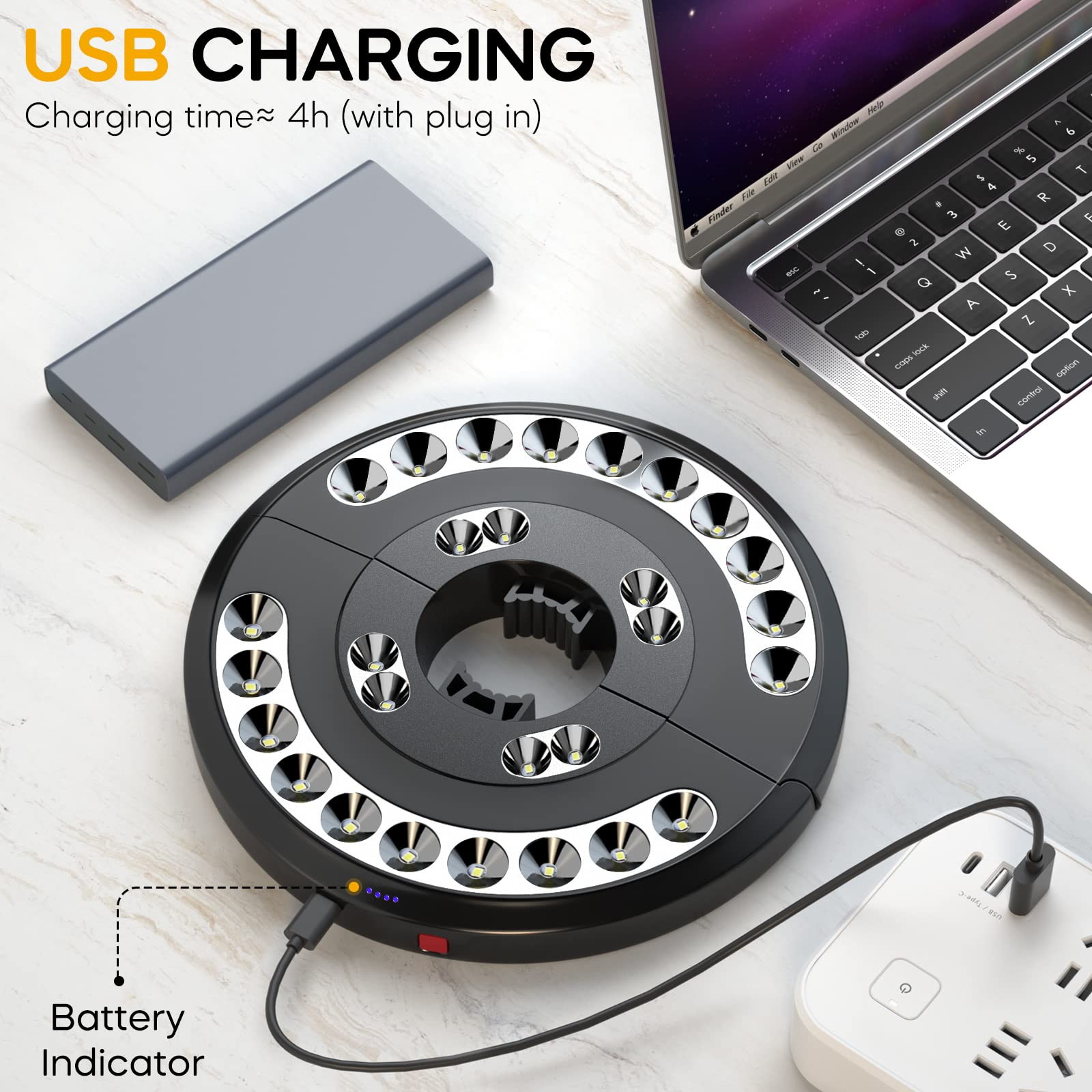 Ein schwarzer Lampenring mit LEDs, daneben ein graues Powerbank, Laptop und eine Steckdose.