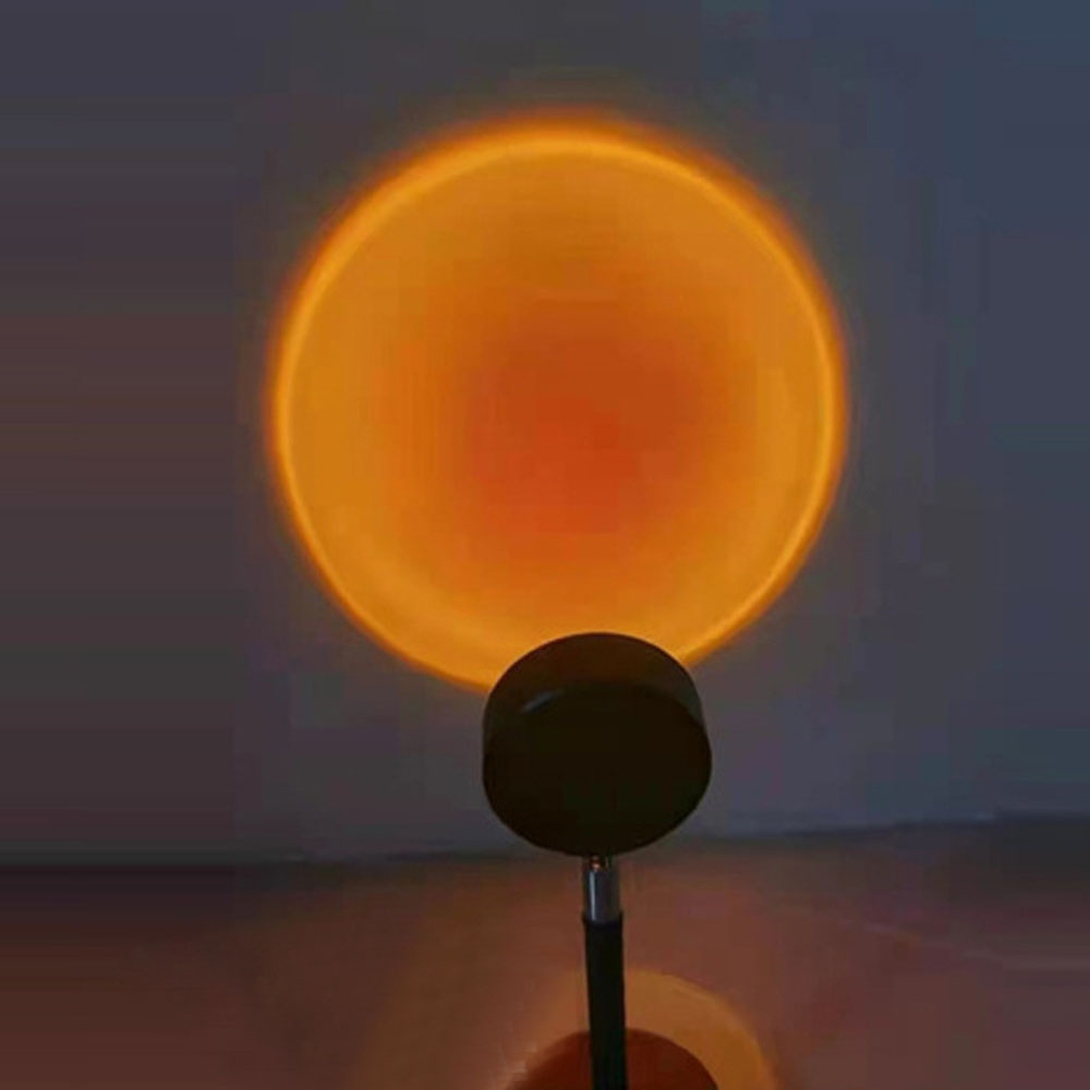 Eine Lampe wirft einen orangen Sonnenuntergangskreis an eine Wand.