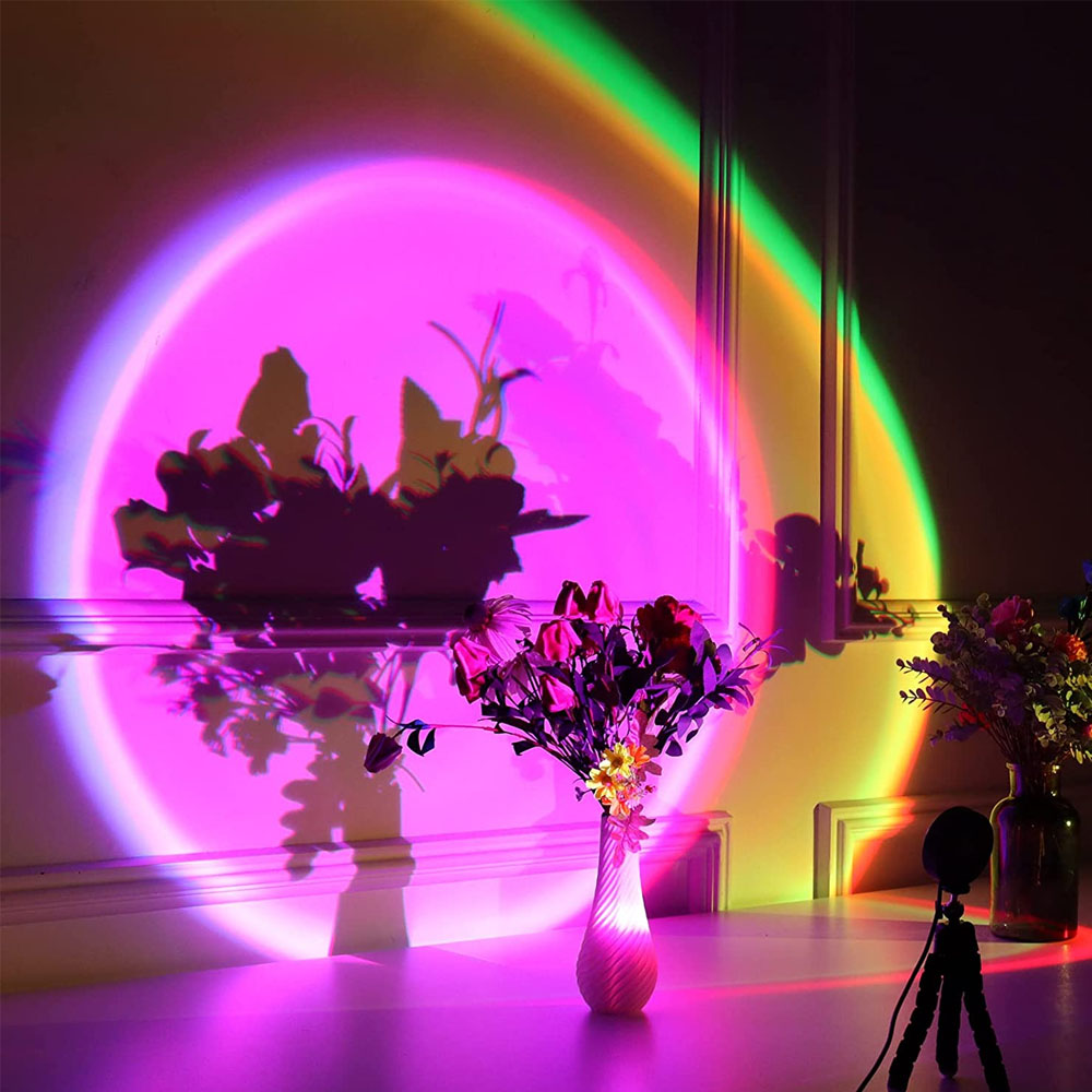 Bunte Lichter projizieren Blumen und Schatten auf eine Wand.