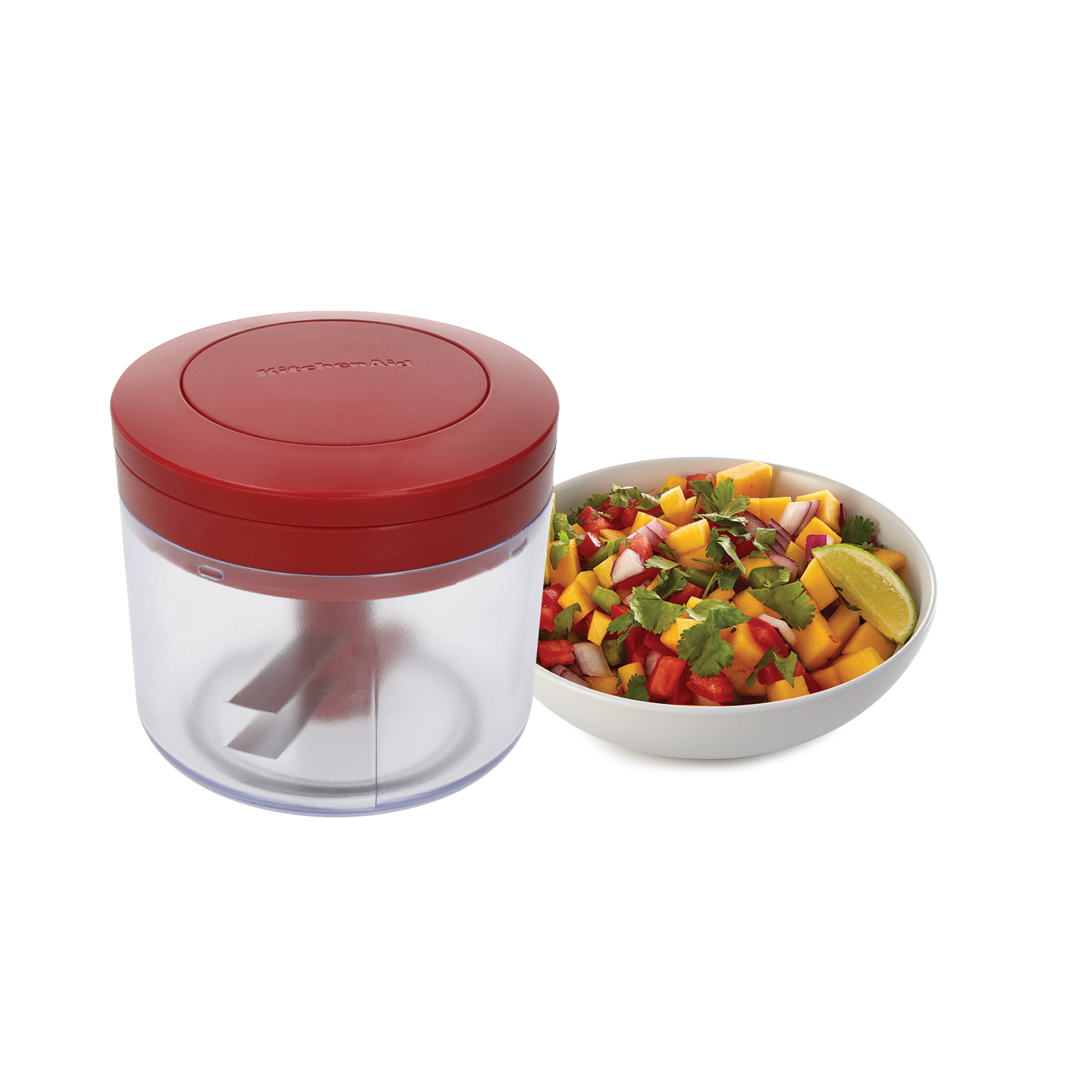 Ein roter Handzerkleinerer neben einer Schüssel mit Mangosalsa.
