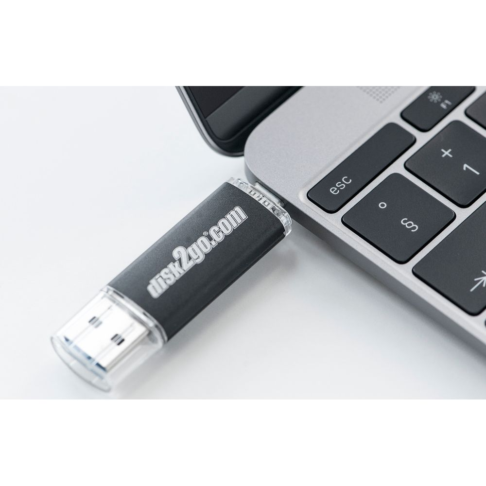 Une clé USB noire "disk2go.com" est branchée sur un ordinateur portable.